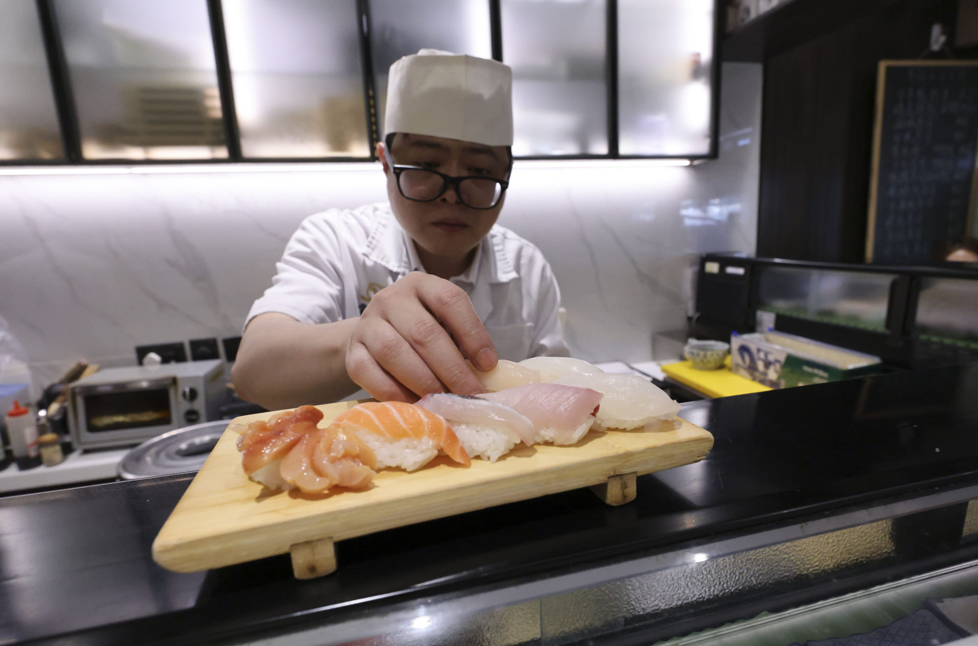 A restaurant worker serves sushi and sashimi to lunchtime customers in Central. Hong Kong has been testing seafood imports from Japan since the waste water discharge. Photo: May Tse