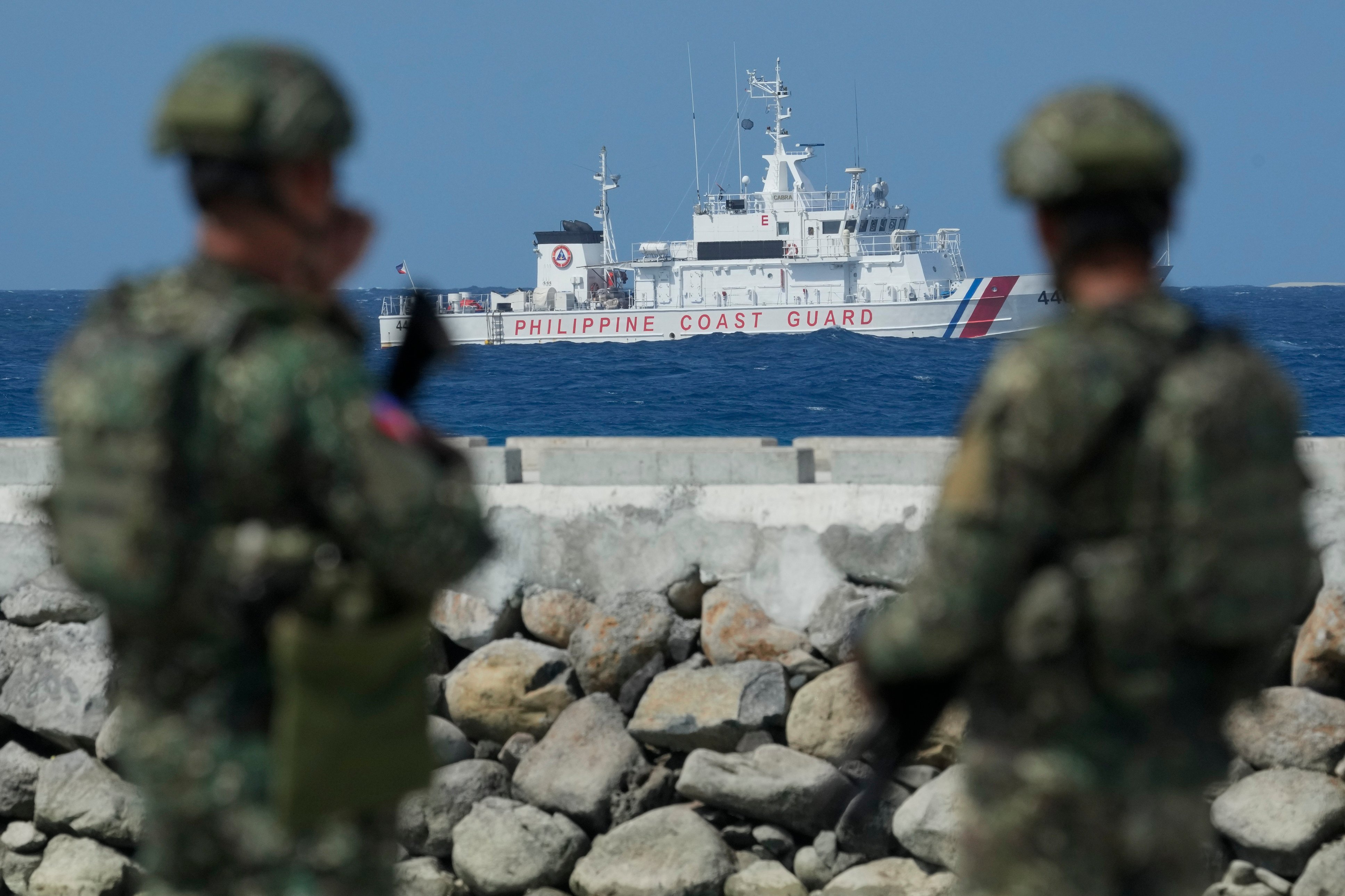 Philippine troops watches a Philippine coastguard ship from the Philippine-occupied Thitu island in the South China Sea on December 1. Photo: AP