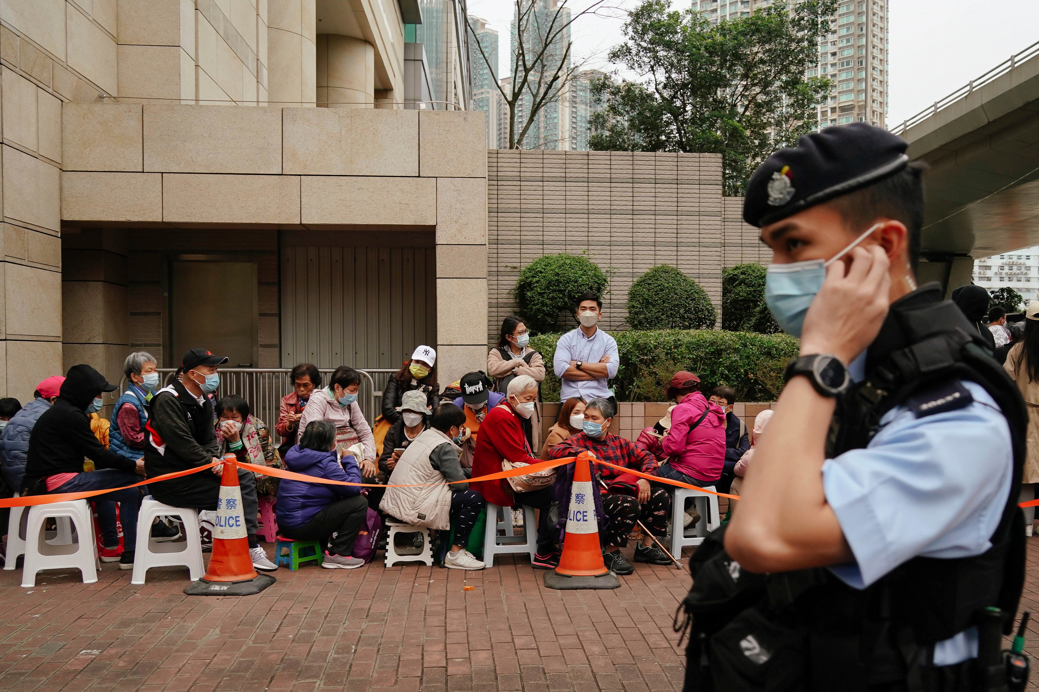 A police officer stands watch as people wait outside the West Kowloon Magistrates’ Courts ahead of the national security trial of pro-democracy activists in Hong Kong on February 6, in the biggest prosecution yet under the law introduced in 2020. Photo: AP