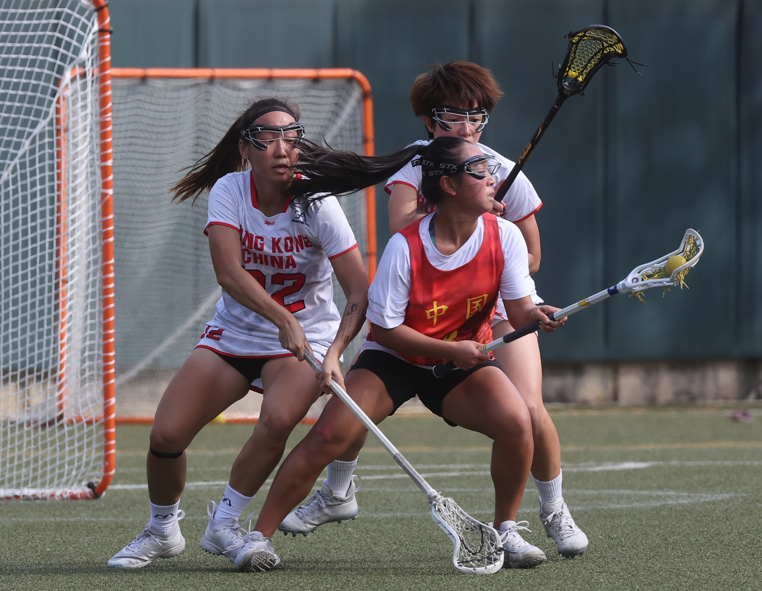 China’s Lin Ruilan (centre), battles for possession with Hong Kong I pair Tang Yi-ting (left) and Hon Cheuk-yee at the World Lacrosse Super Sixes . Photo: Edmond So