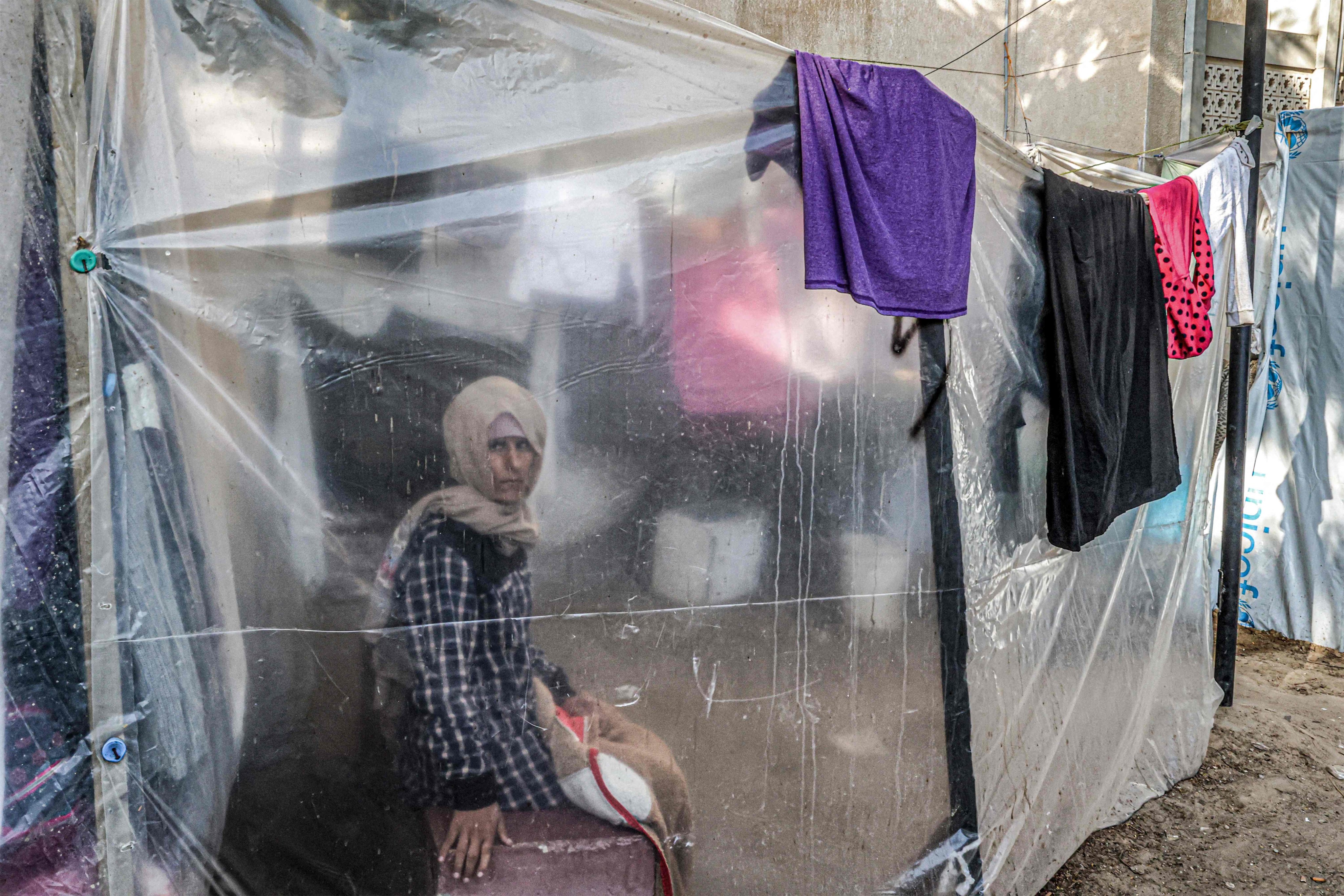 A woman looks on from behind a plastic screen at a camp for displaced Palestinians in Khan Yunis, southern Gaza. Photo: AFP