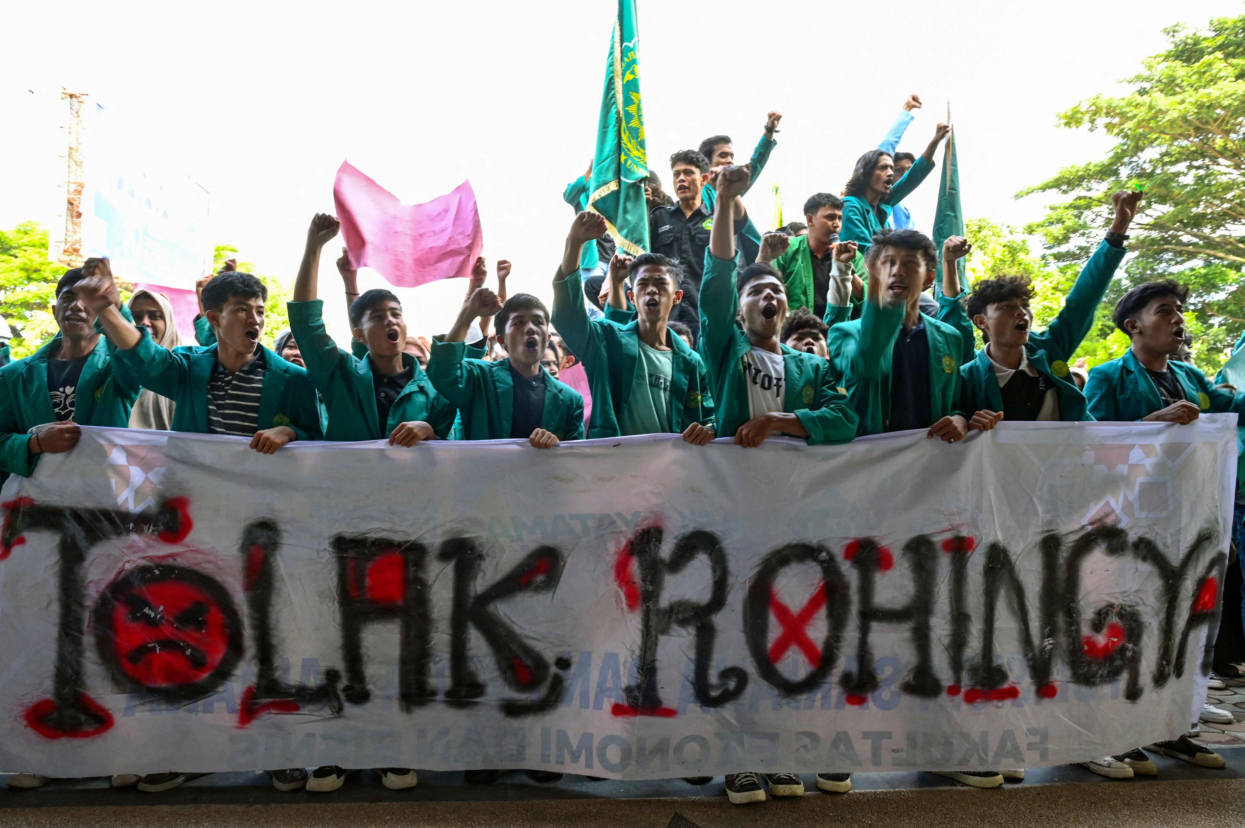 University students hold a banner that reads “reject the Rohingya” as they demonstrate against the arrival of Rohingya refugees in Banda Aceh last Wednesday. Photo: AFP