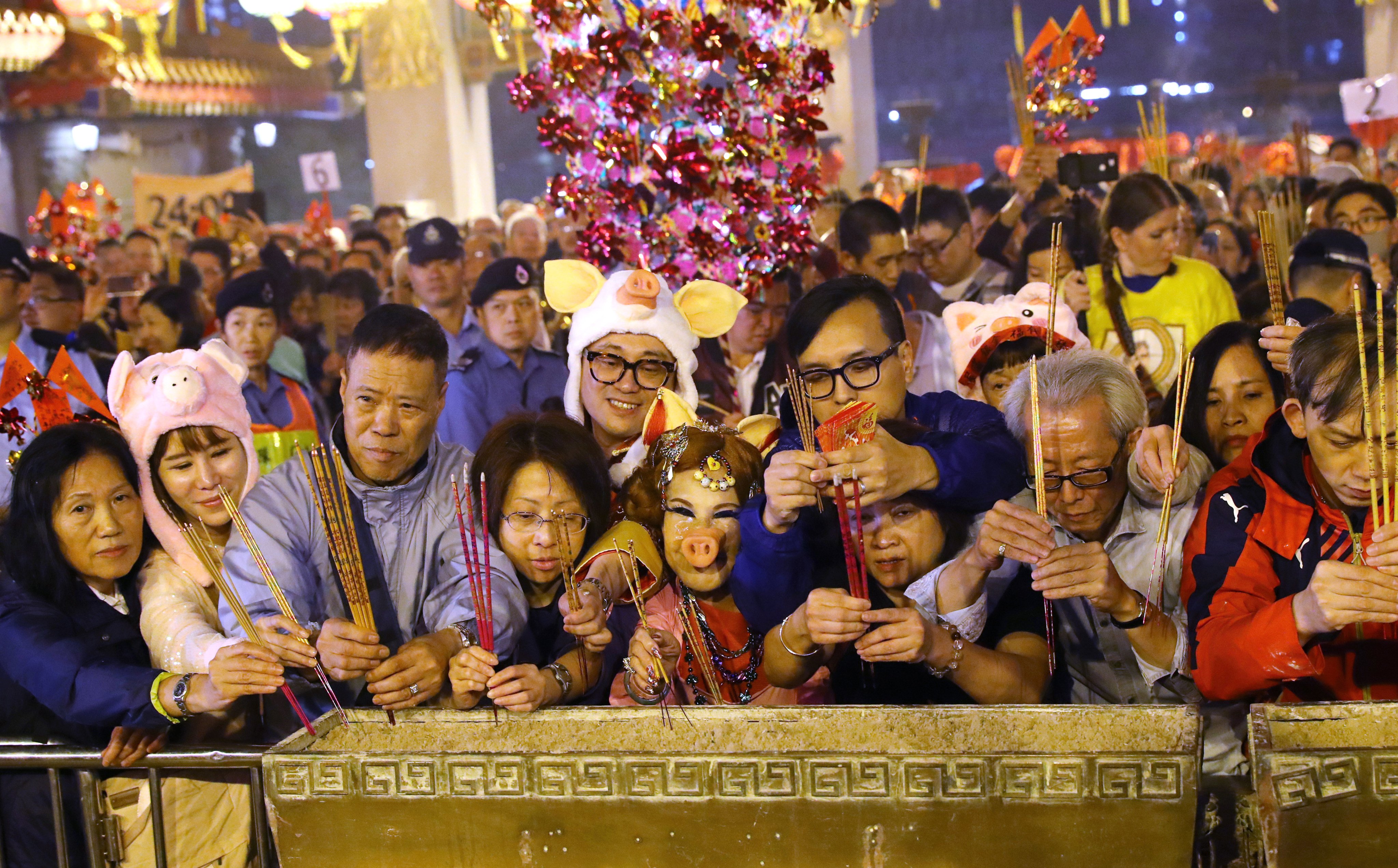 Worshippers, including a woman dressed in a pig costume, offer incense at Wong Tai Sin Temple in Hong Kong on Lunar New Year’s Eve in 2019. Festivities for Chinese New Year run to 16 days, with different traditions attached to each day. Photo: Edmond So