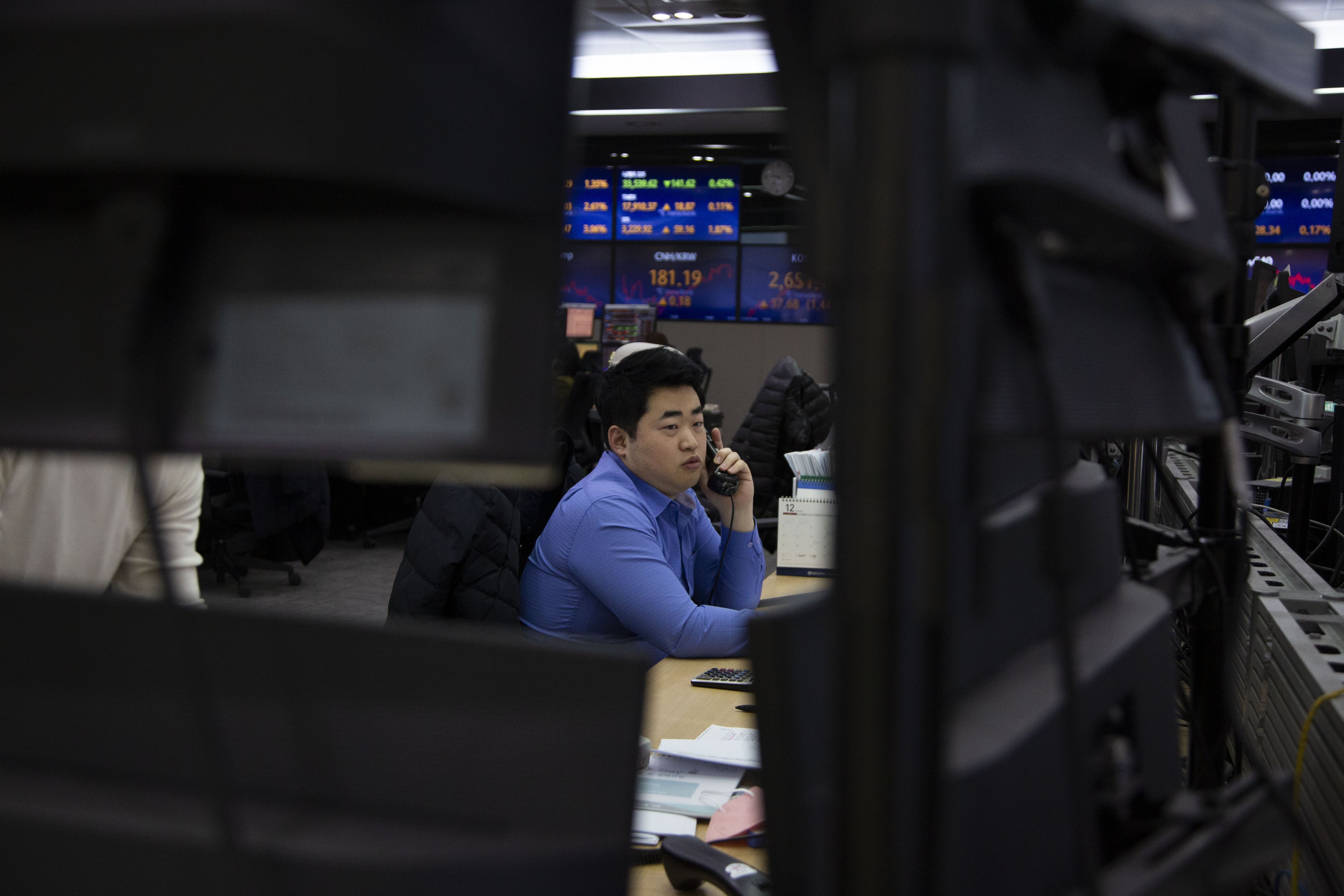 A trader works in front of a bank of monitors at a bank in Seoul on December 28. The lengthening of won trading hours is part of South Korea’s bid to improve access and boost the case for recognition as a developed market. Photo: EPA-EFE