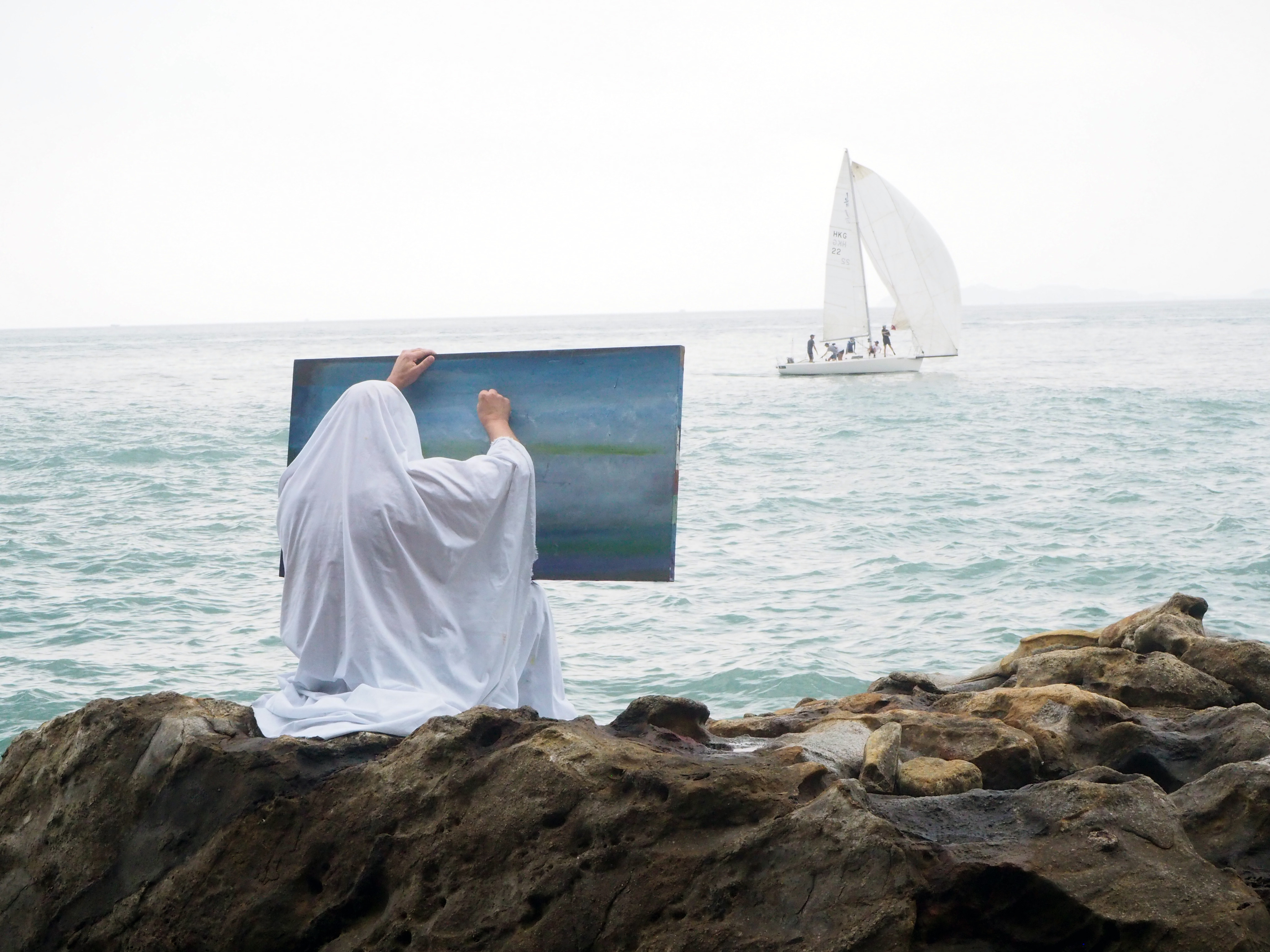 Belgium-based Spanish artist Angel Vergara paints a sea scene in Hong Kong while covered in his signature white cloth. Photo: Axel Vervoordt Gallery