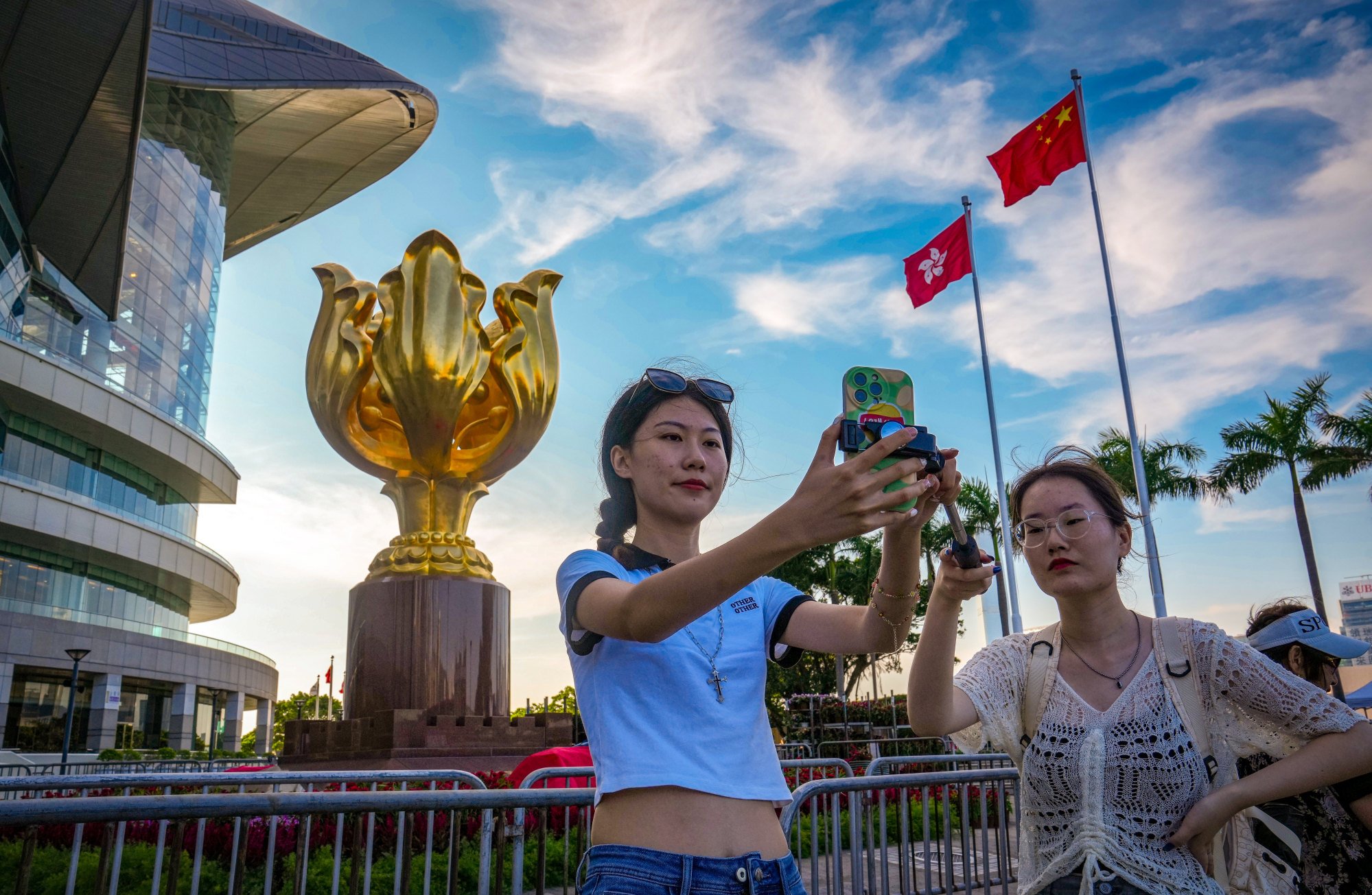Visitors take selfies at Golden Bauhinia Square in Wan Chai. The tourism sector still faces a shortage of workers amid a slower-than-expected recovery. Photo: Sam Tsang