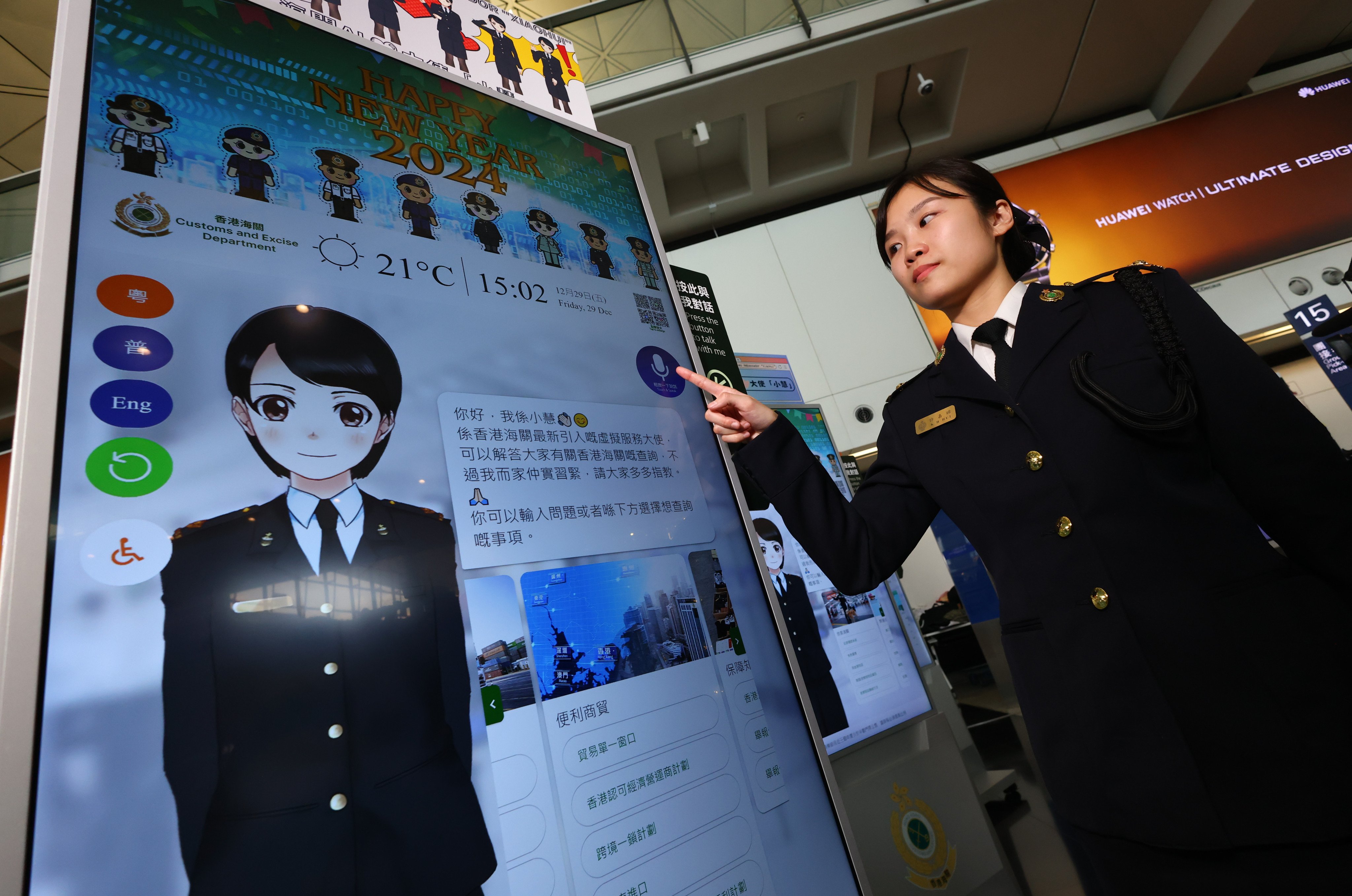 Customs inspector Hui Ka-hei explains how XiaoHui, a virtual ambassador introduced at Hong Kong’s airport and three control points, works to to handle public enquiries, on December 29. Photo: Dickson Lee