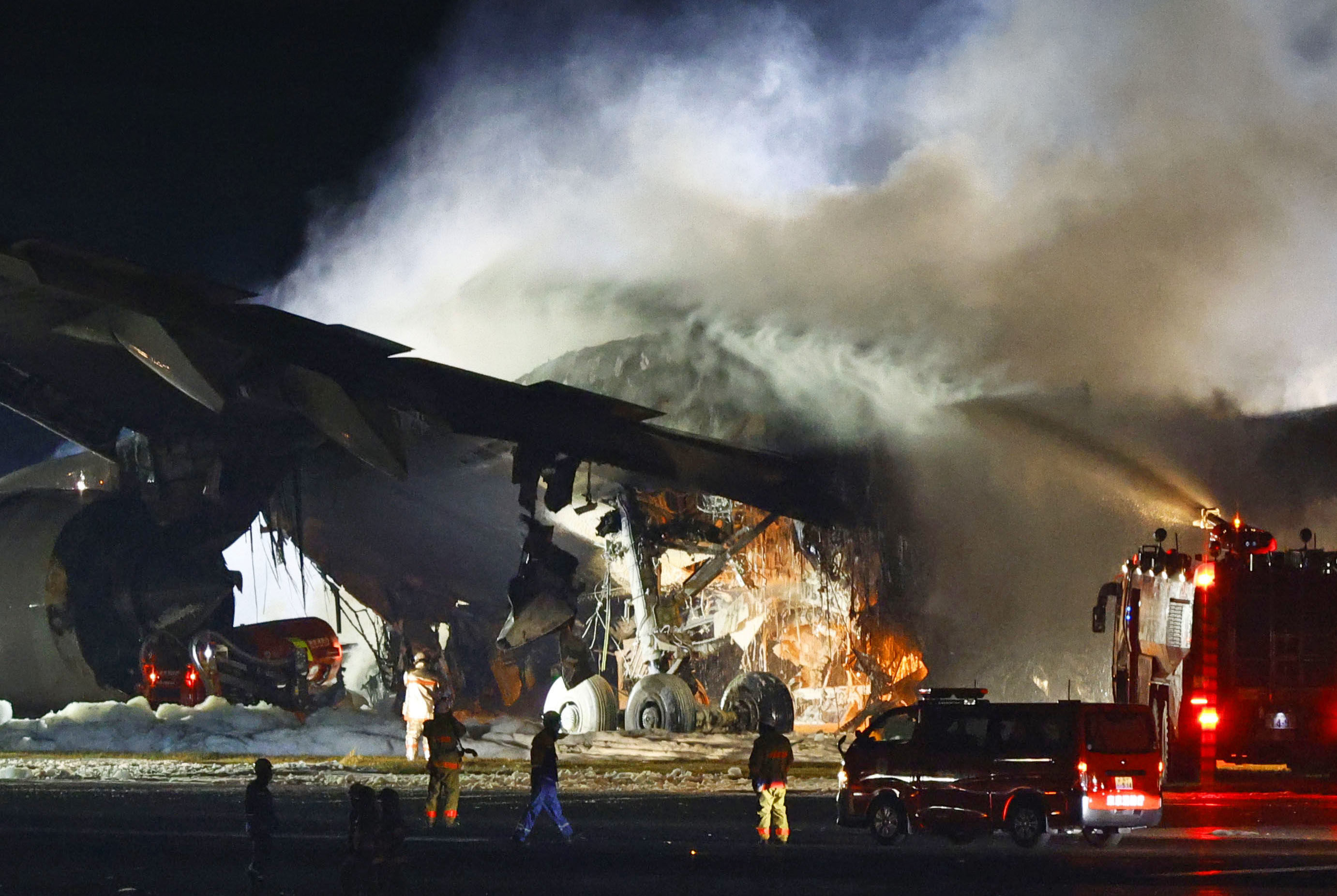 Firefighters battle the blaze that broke out on the Japan Airlines plane after it had collided with a coastguard aircraft on a runway at Haneda airport in Tokyo on Tuesday evening. Photo: Kyodo