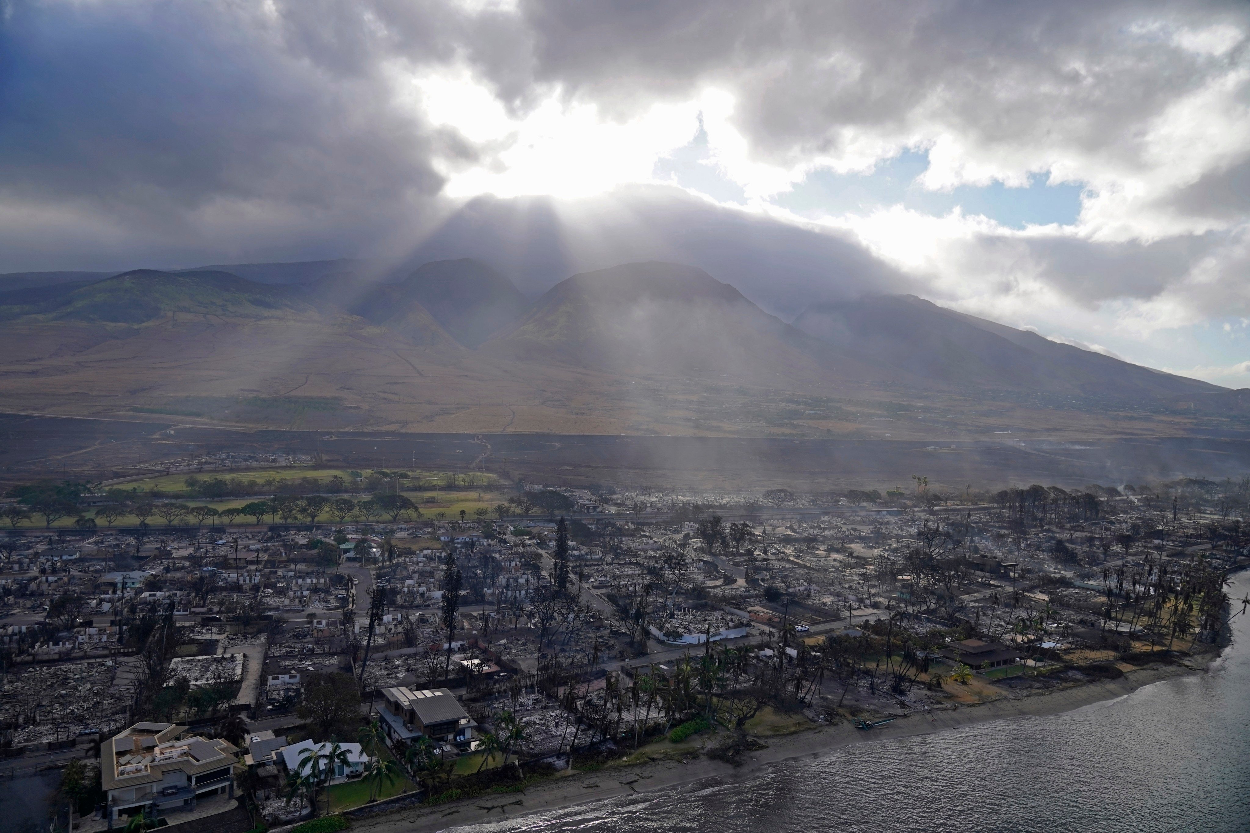 The sun shines through the clouds over Lahaina, Hawaii, on August 10, 2023, after the city saw widespread destruction from wildfires. Photo: AP