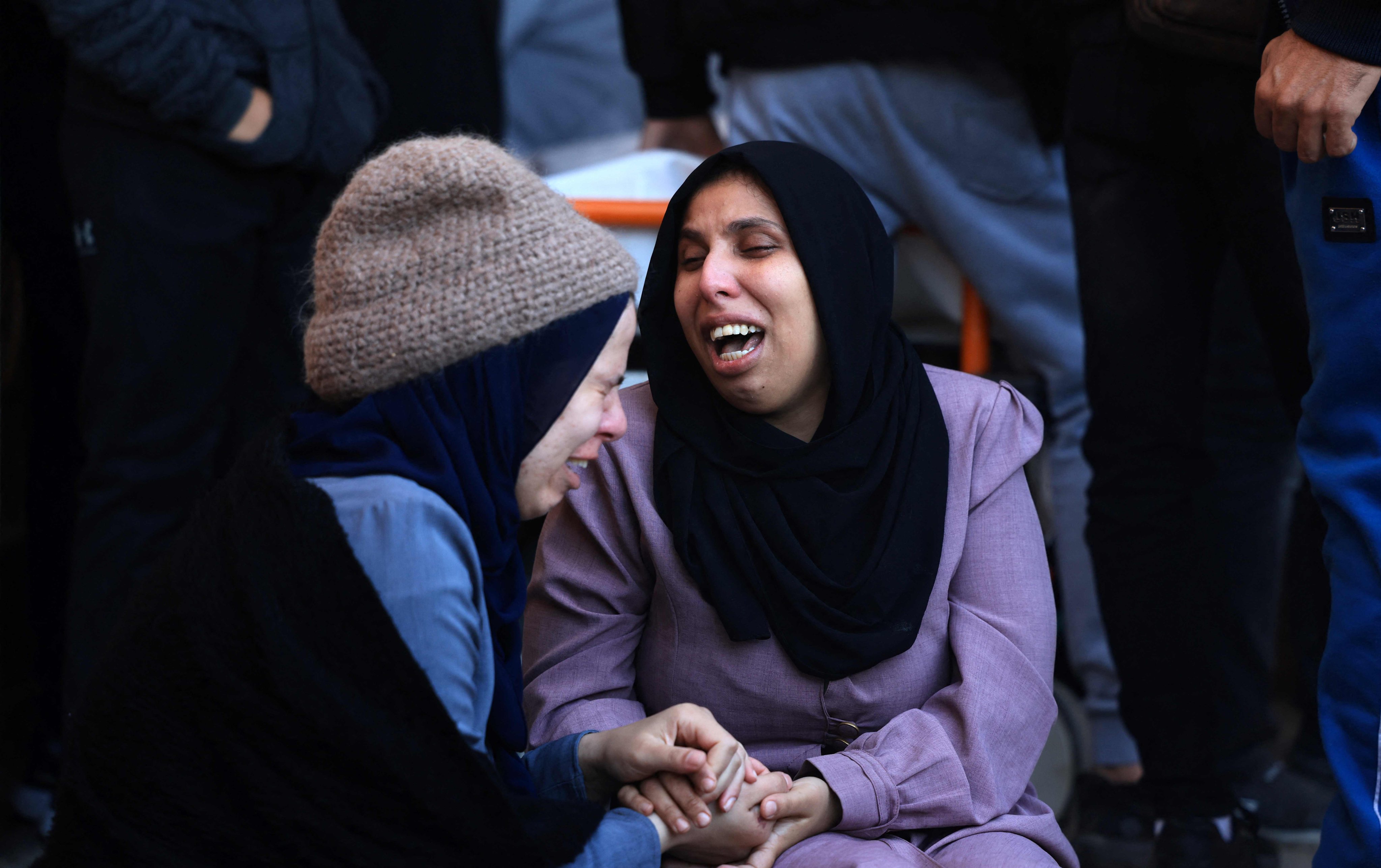 A woman (R) mourns her husband, killed when the tent they were sheltering in was hit by Israeli bombardment. Photo: AFP