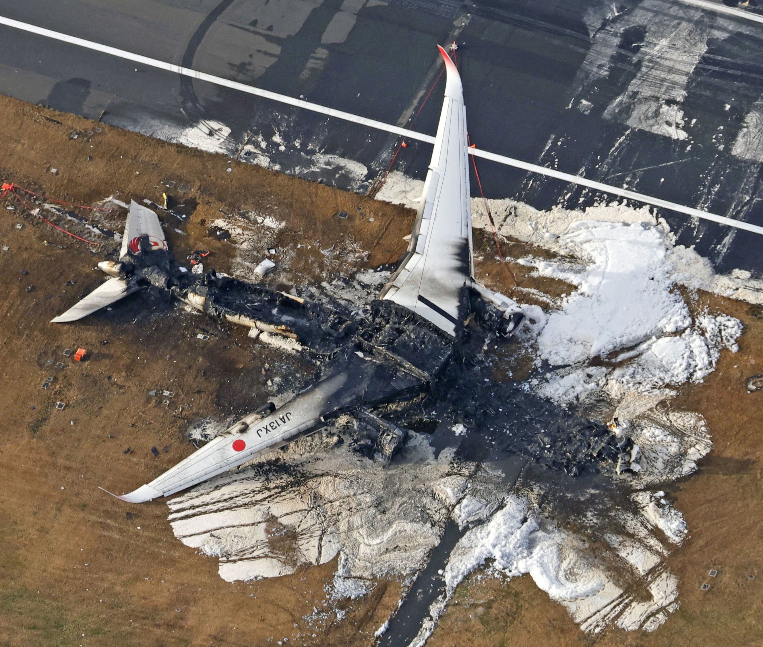 The burnt Japan Airlines plane after a collision with a coastguard aircraft at Haneda airport in Tokyo. Photo: Kyodo via Reuters