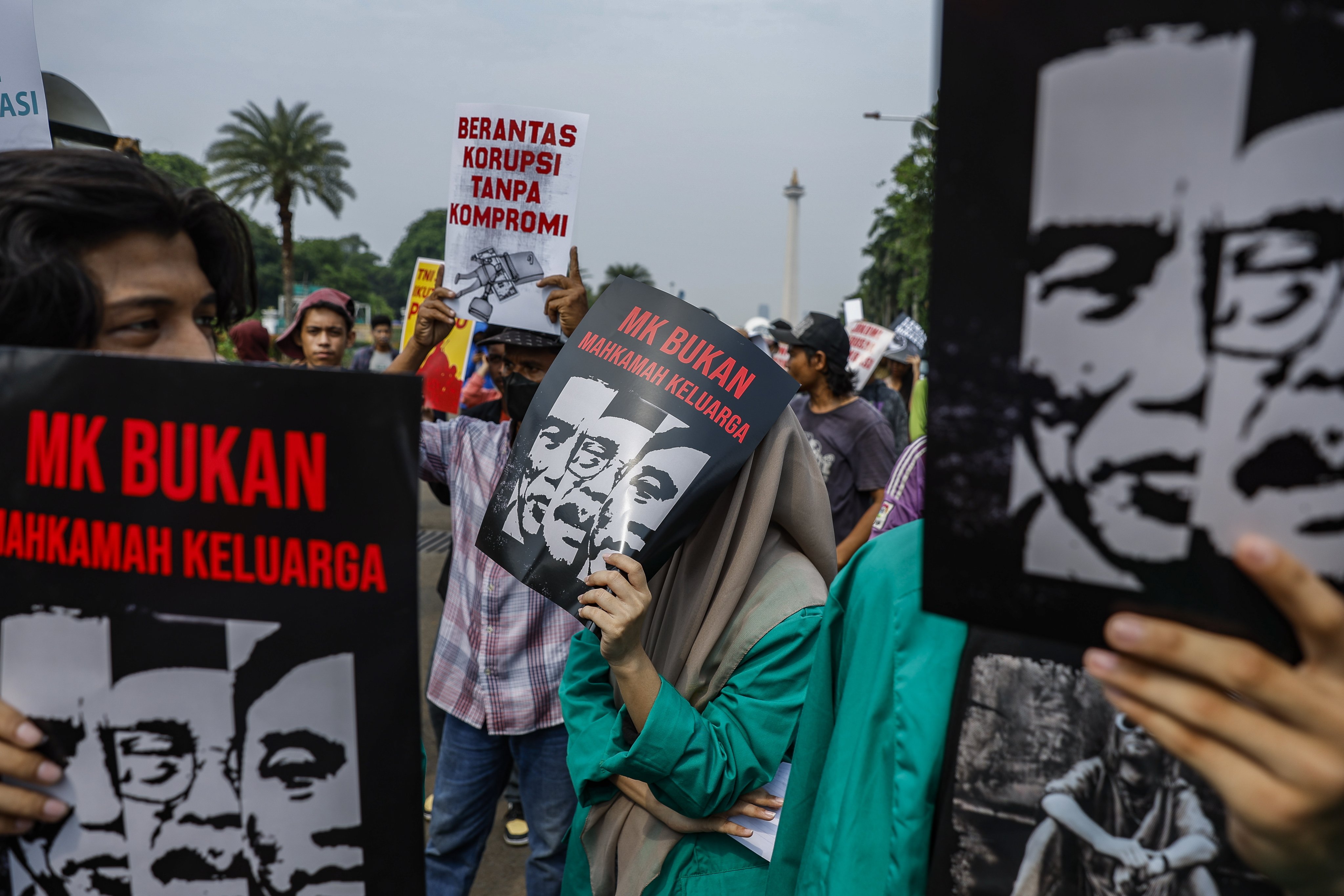 Protesters hold placards with pictures of Indonesian President Joko Widodo, his son Gibran Rakabuming Raka and the former constitutional court chief during a rally against political dynasties in Jakarta on December 7. Photo: EPA-EFE