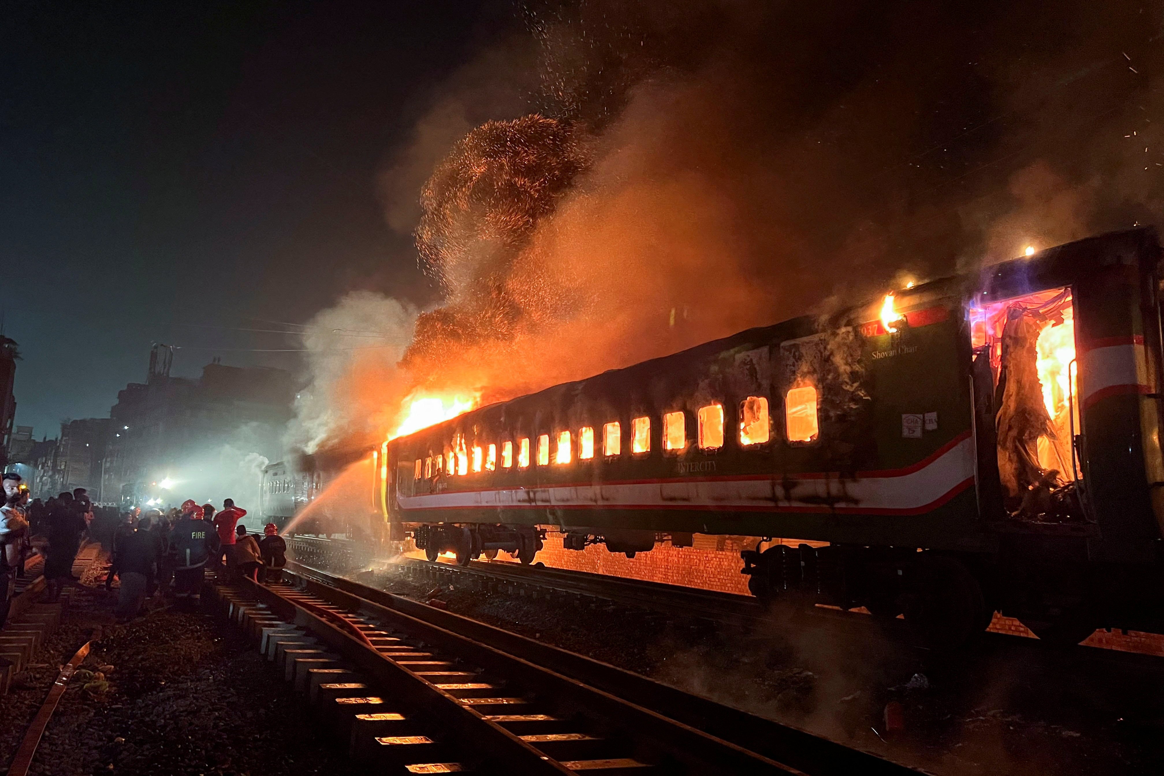 Firefighters attempt to extinguish a fire on a passenger train in Dhaka, Bangladesh on Friday. Photo: Reuters 