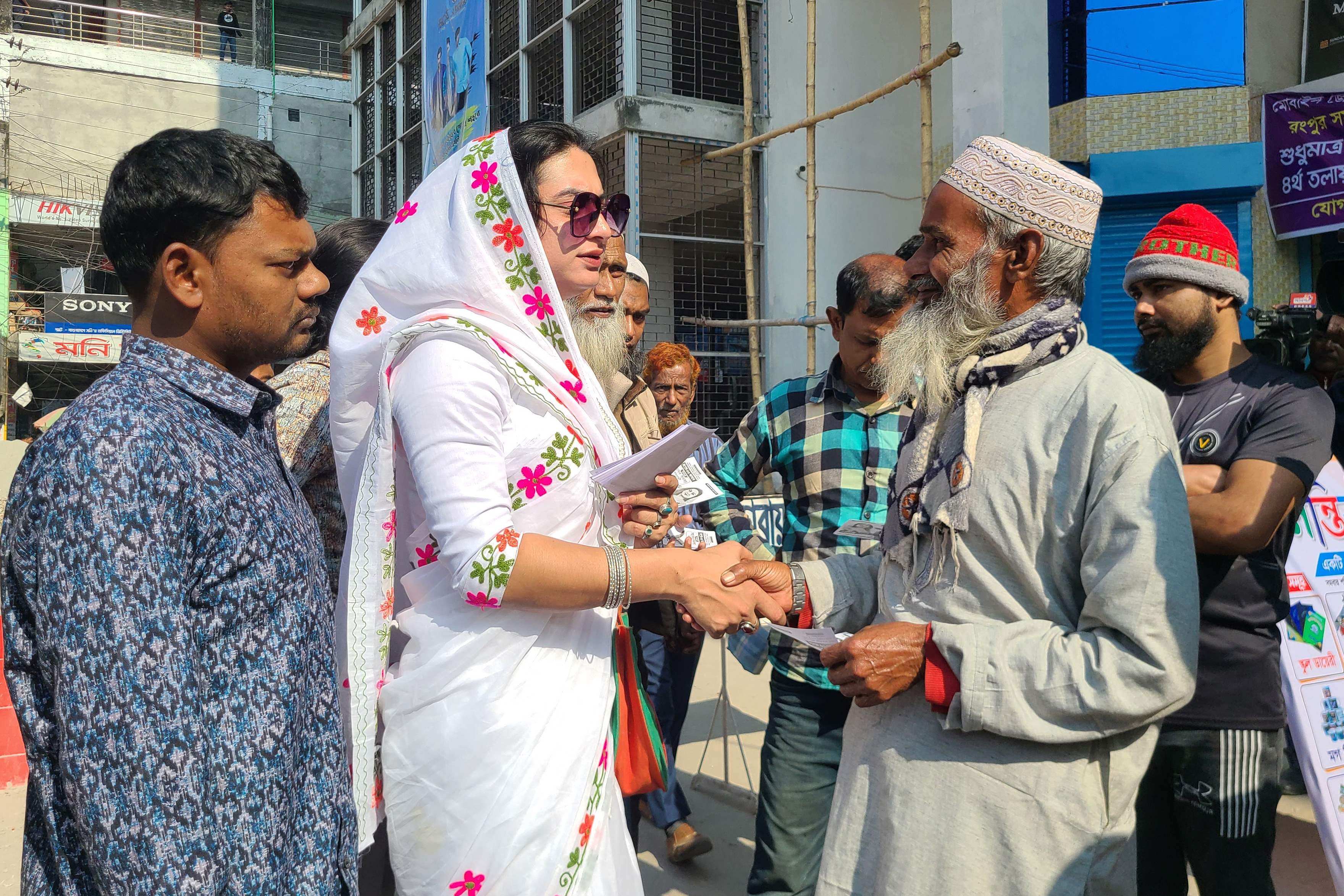 Transgender candidate Anwara Islam Rani shakes hands with a man during a campaign event in Rangpur, ahead of Bangladesh’s general election on Sunday. Photo: AFP