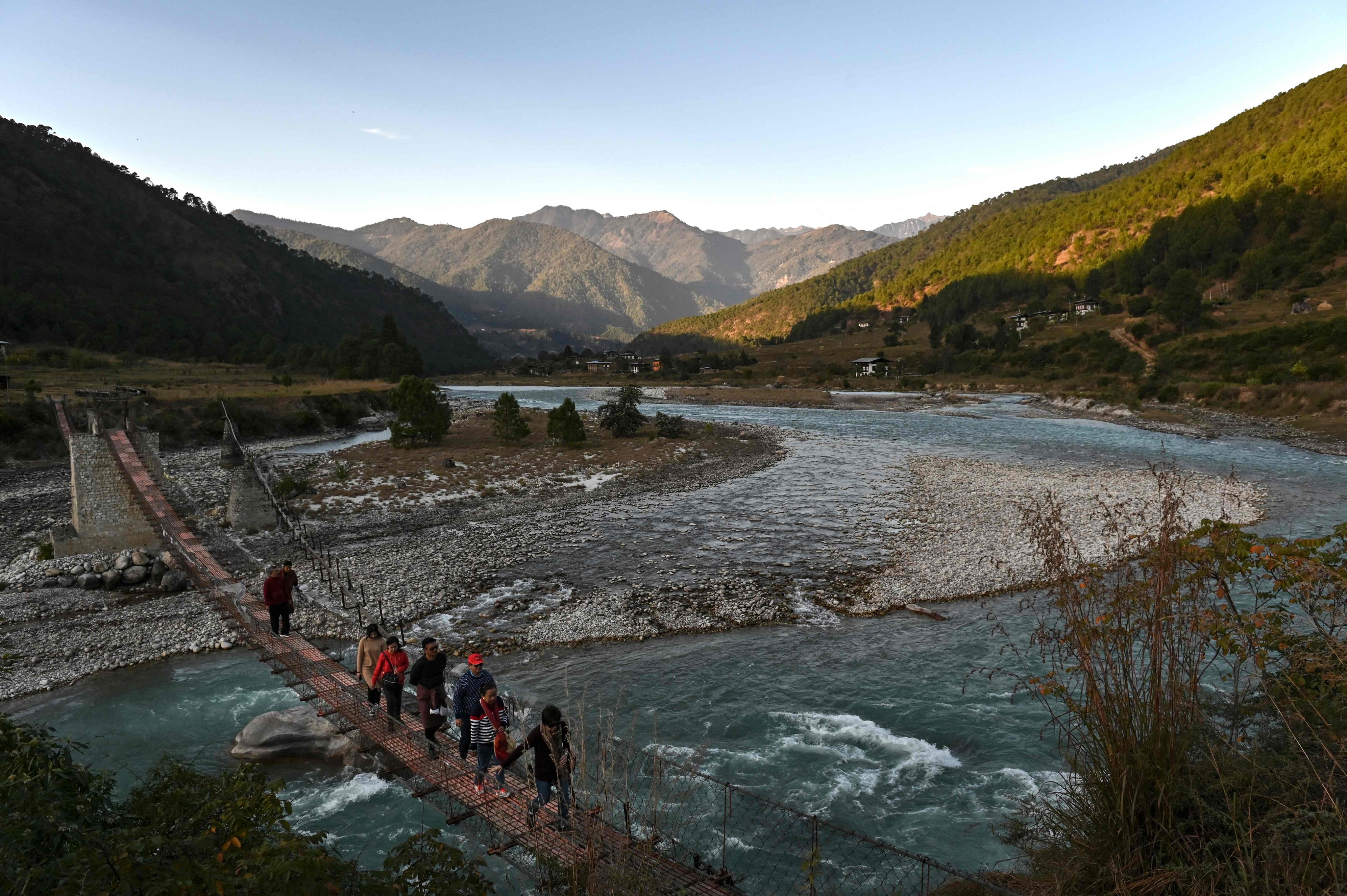 Tourists walking across a suspension bridge over the Puna Tsang Chhu River in Punakha province in Bhutan. Photo: AFP