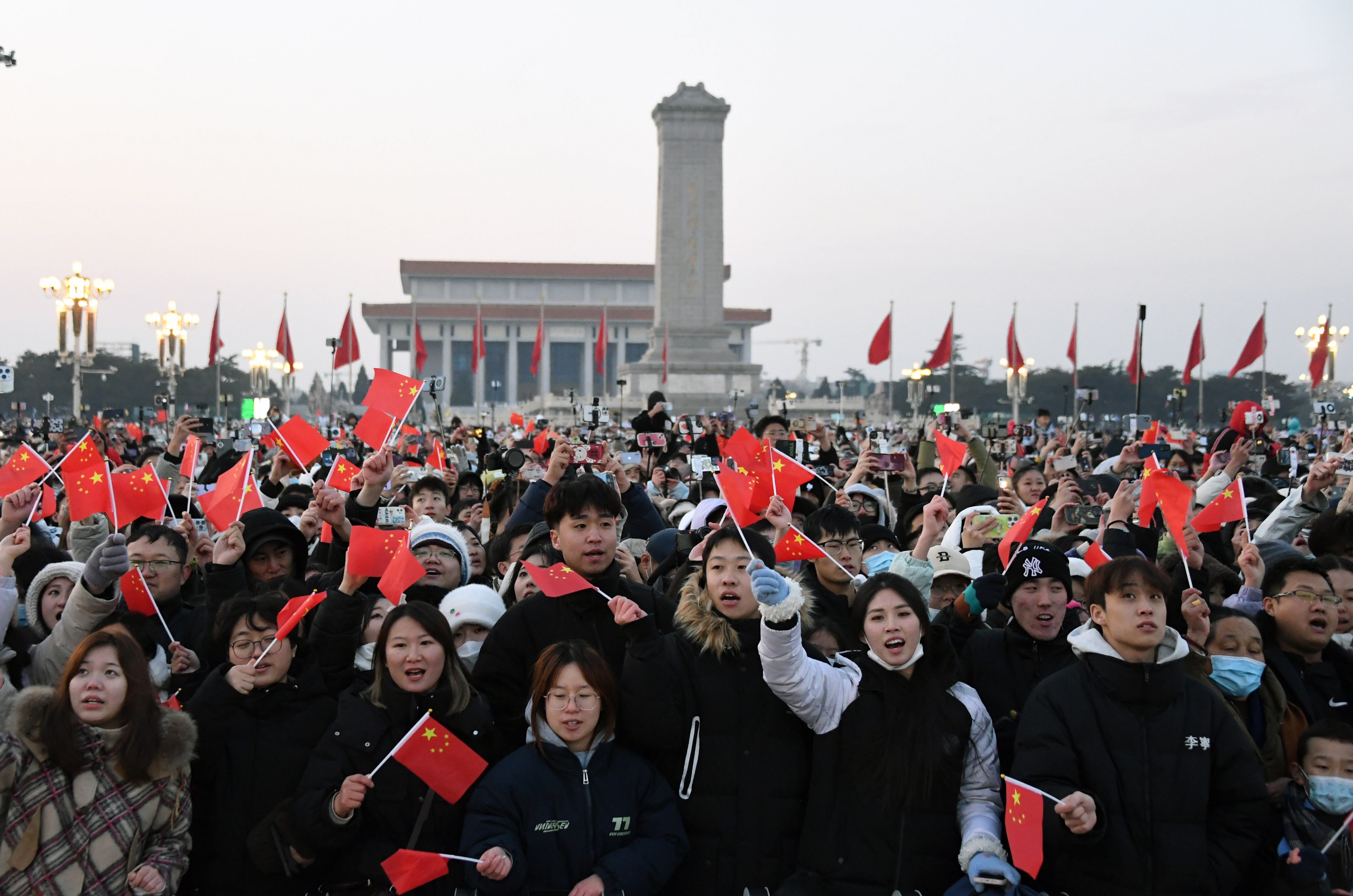 People cheer after a national-flag-raising ceremony at Tiananmen Square in Beijing on January 1. To realise its dream of national rejuvenation, China must do more to protect property rights and honour social contracts. Photo: Xinhua