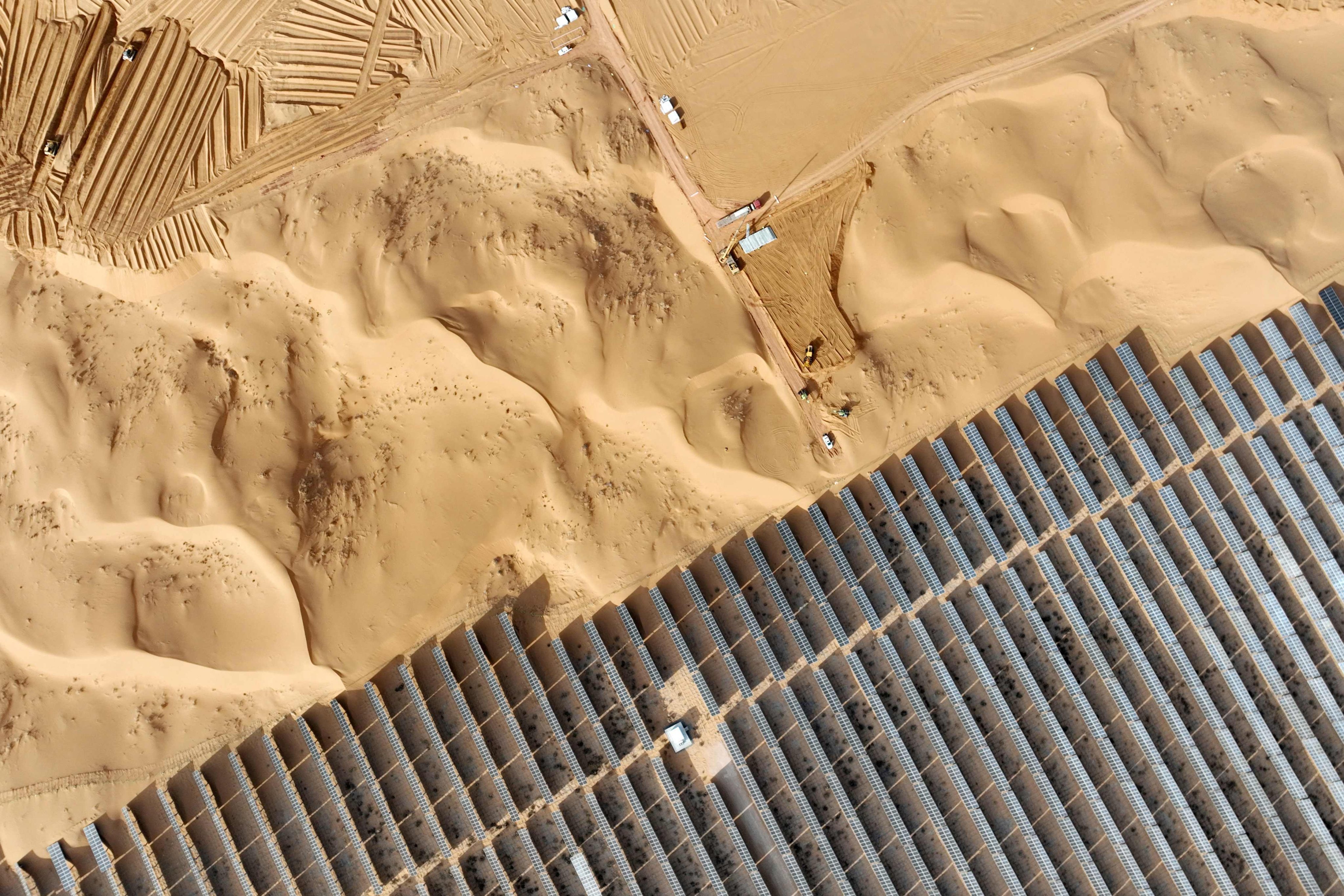 Vehicles are seen near solar panels during construction at the Ningxia Tengger Desert New Energy Base, in China’s northern Ningxia region, on December 9. Photo: AFP