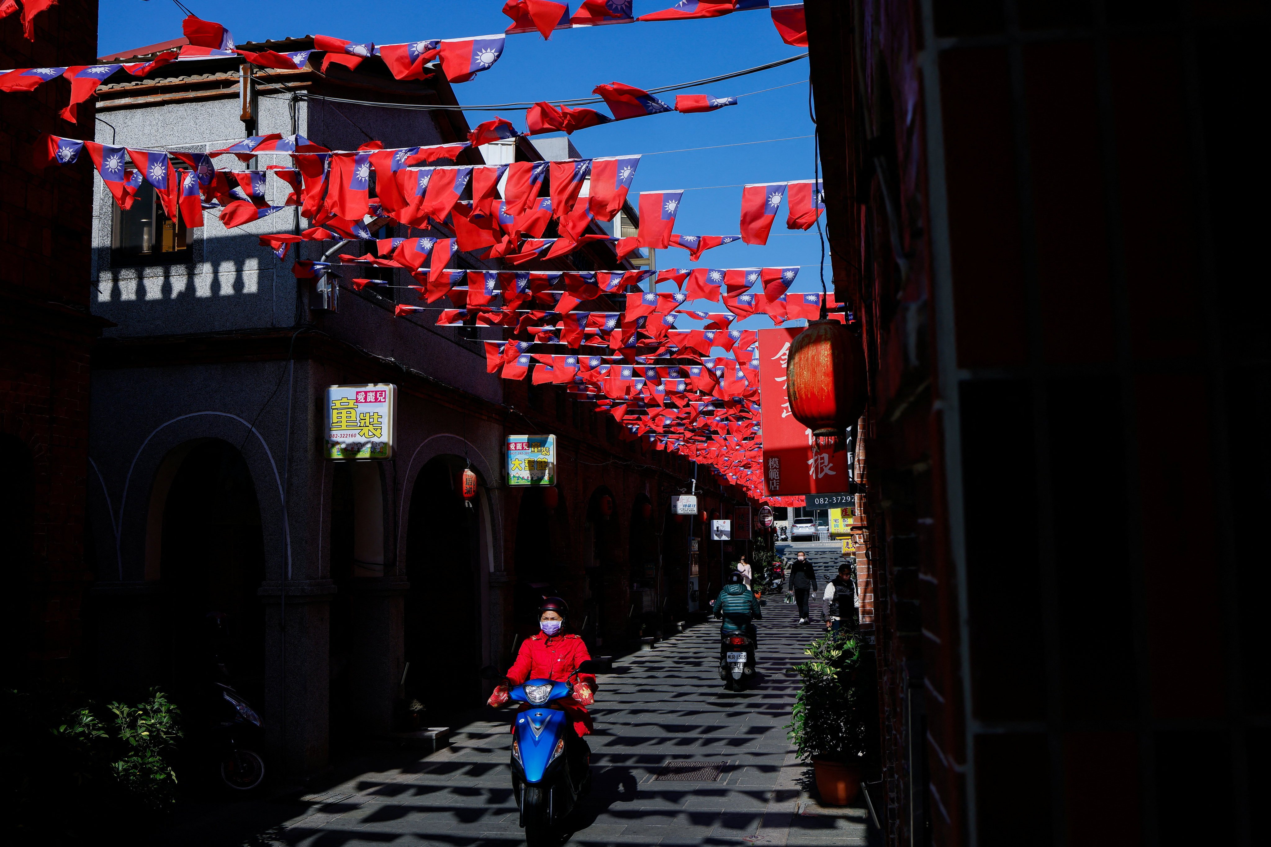 People pass through a street decorated with Taiwanese flags in Kinmen, Taiwan, on December 18, 2023. Taiwan’s presidential and legislative elections are scheduled for January 13. Photo: Reuters