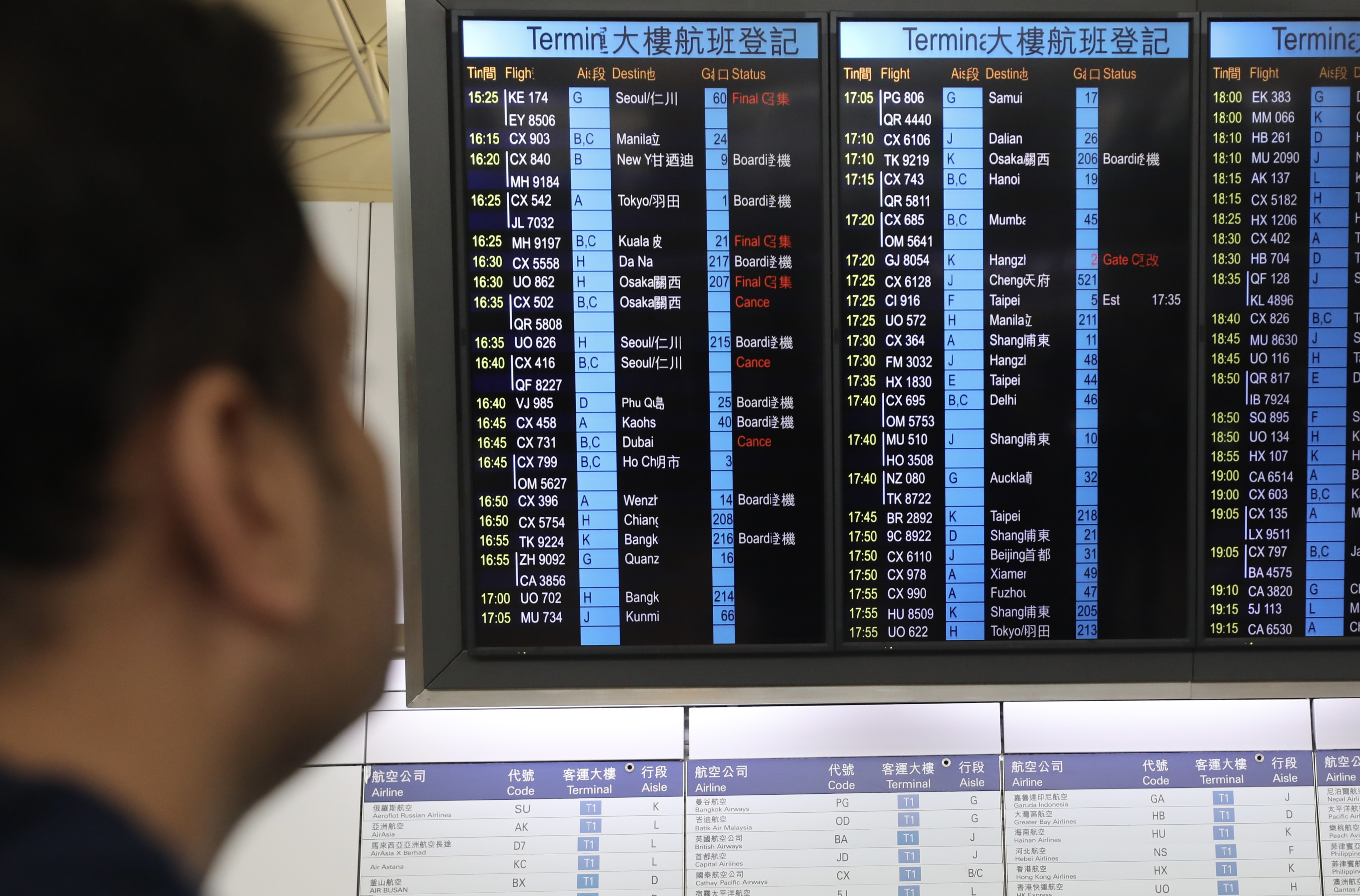 A passenger checks an information board at Hong Kong International Airport showing Cathay Pacific flight cancellations. Photo: Xiaomei Chen