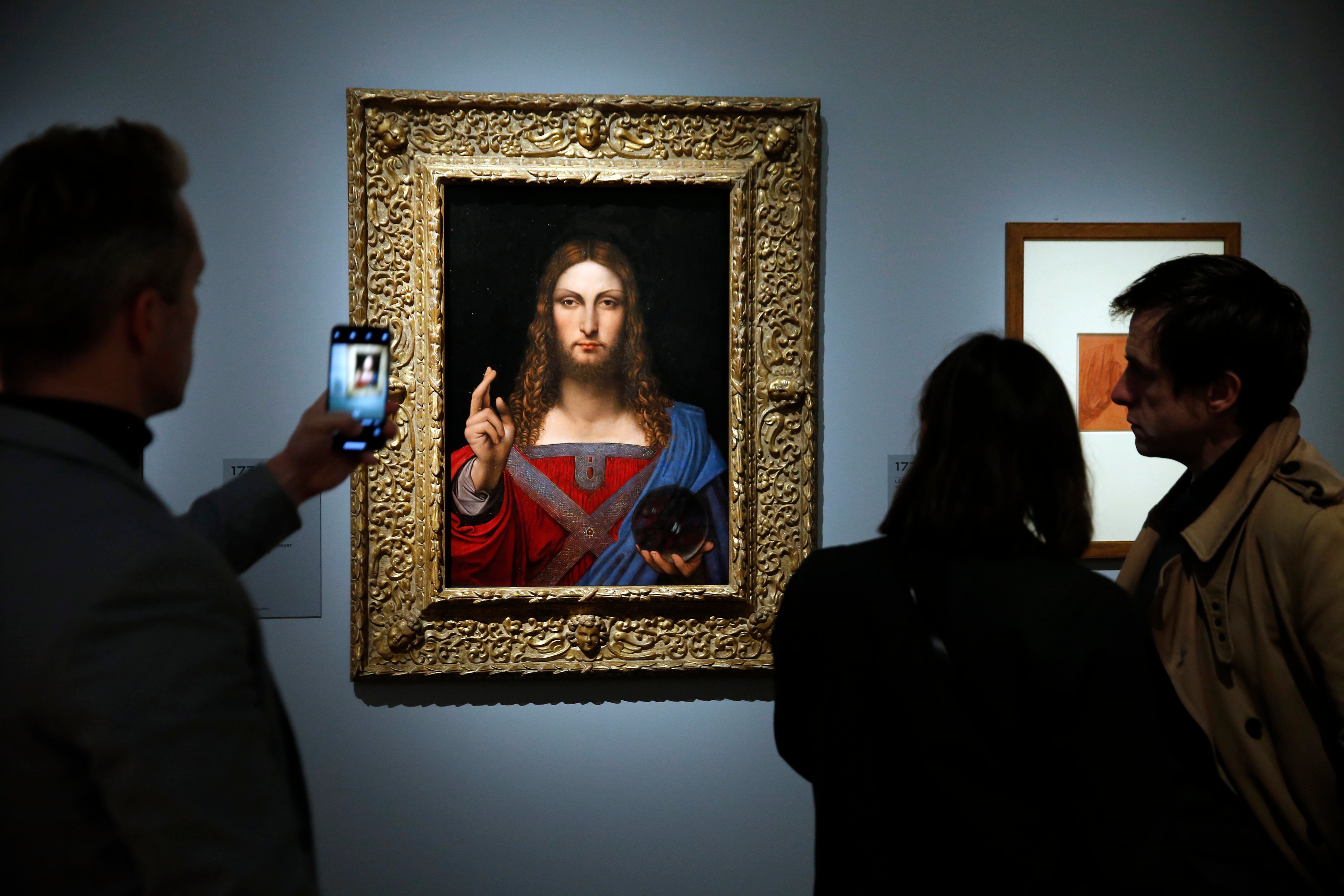 Visitors look at “Salvator Mundi” by Leonardo da Vinci at the Louvre museum on October 22, 2019 in Paris. France. The painting is among those that Russian billionaire Dmitry Rybolovlev claims he was defrauded over in a scheme involving auction house Sotheby’s and art broker Yves Bouvier. Photo: Getty Images