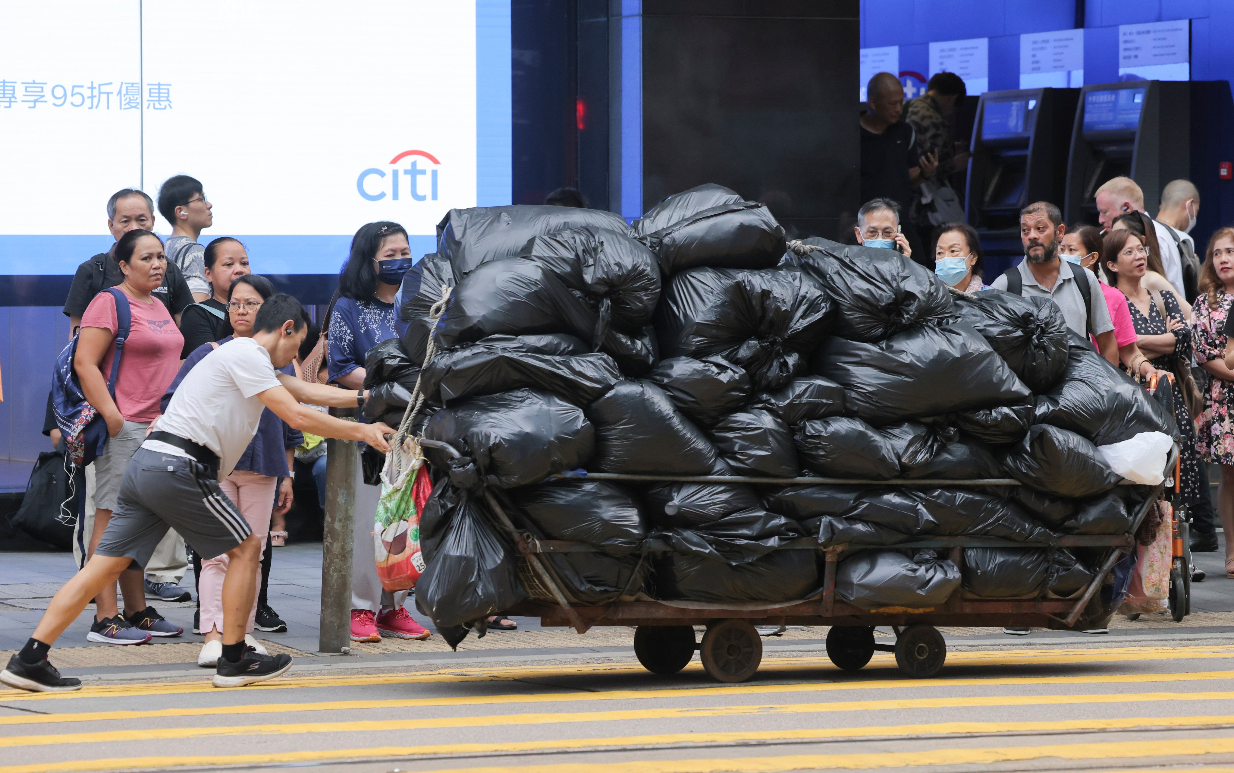 A man pushes a cart of rubbish through Central, Hong Kong, on August 17. It will take time for the community to understand the long-term benefits and importance of recycling and sustainable waste management. Photo: Jelly Tse