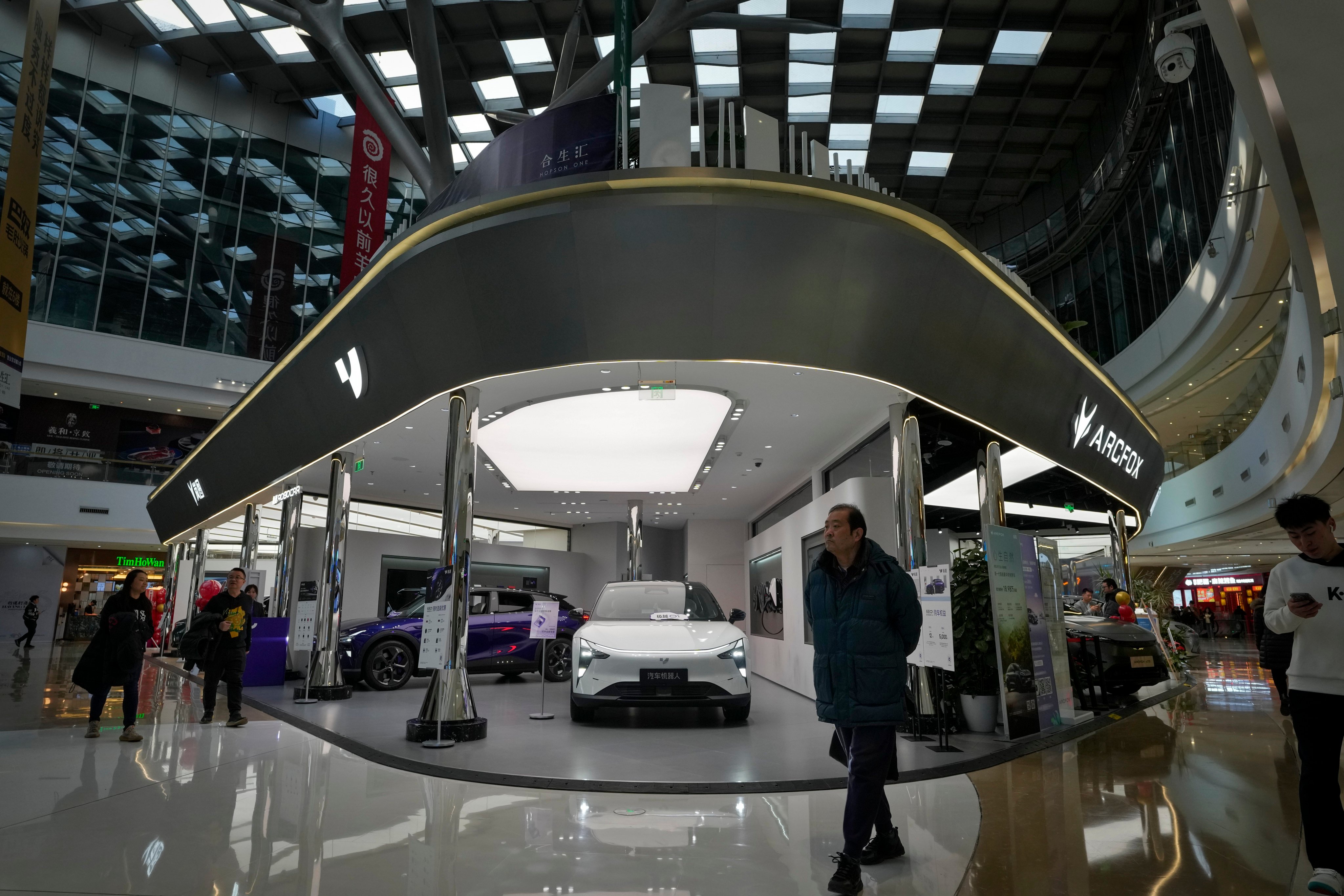People walk through a section of a mall in Beijing selling various Chinese-made electric cars brands. China’s car exports and domestic sales surged in 2023. Photo: AP Photo