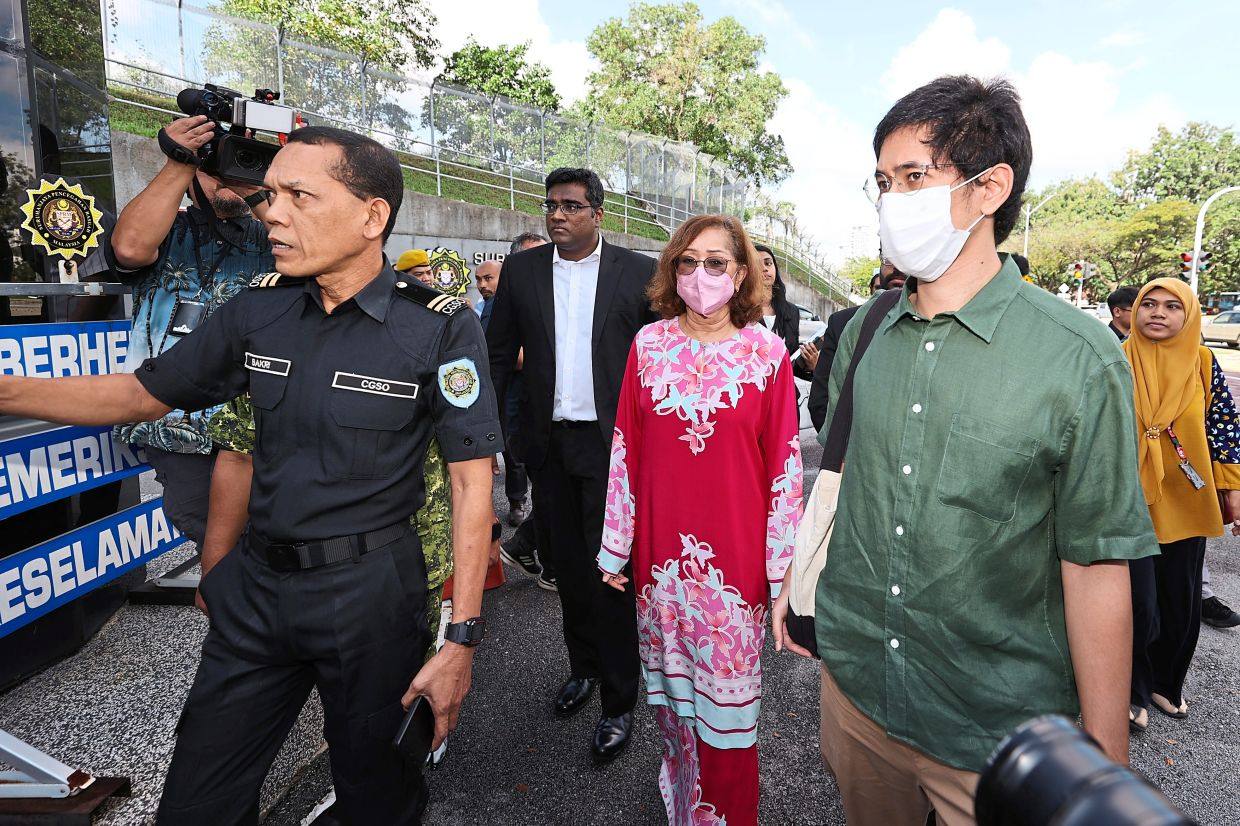 Naimah Khalid with one of her sons (right) entering the MACC’s headquarters in Putrajaya, Malaysia, on January 10. Photo: The Star