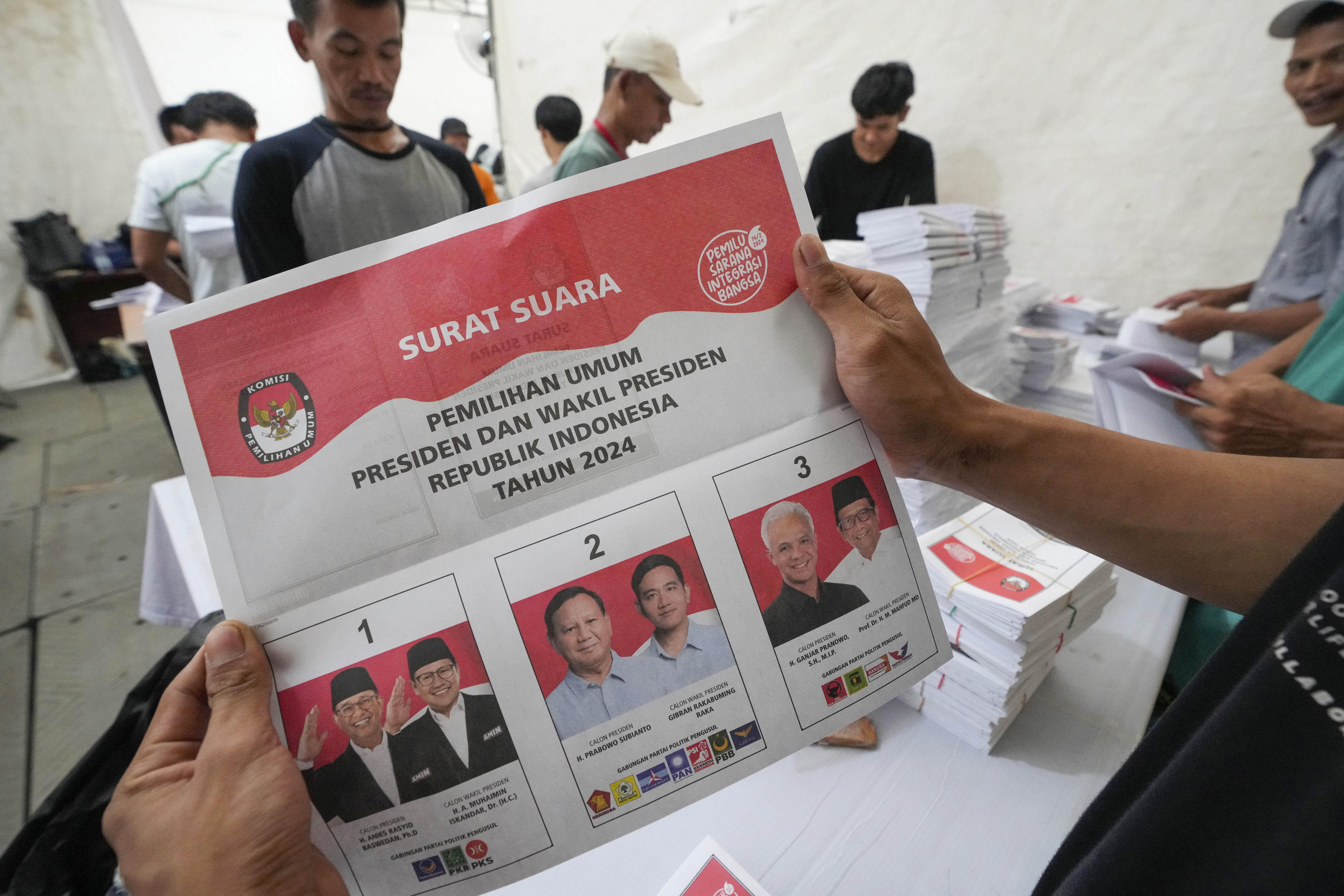 A worker holds a ballot for the February 14 presidential election showing candidates, from left, Anies Baswedan and running mate Muhaimin Iskandar, Prabowo Subianto and running mate Gibran Rakabuming Raka, and Ganjar Pranowo and his running mate Mahfud MD. Photo: AP