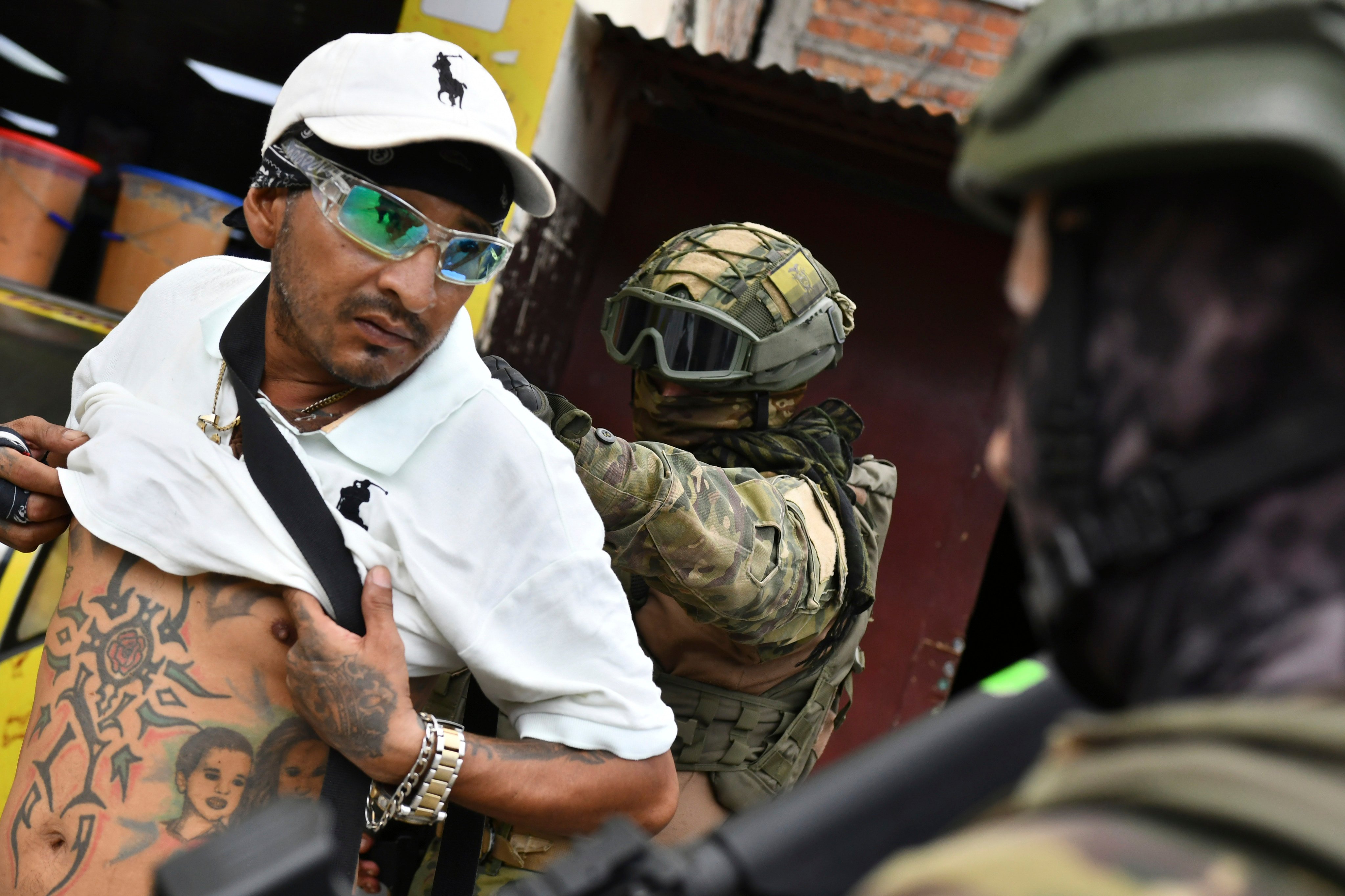 A soldier checks a man for gang tattoos during an  operation in Portoviejo, Ecuador. Photo: AP