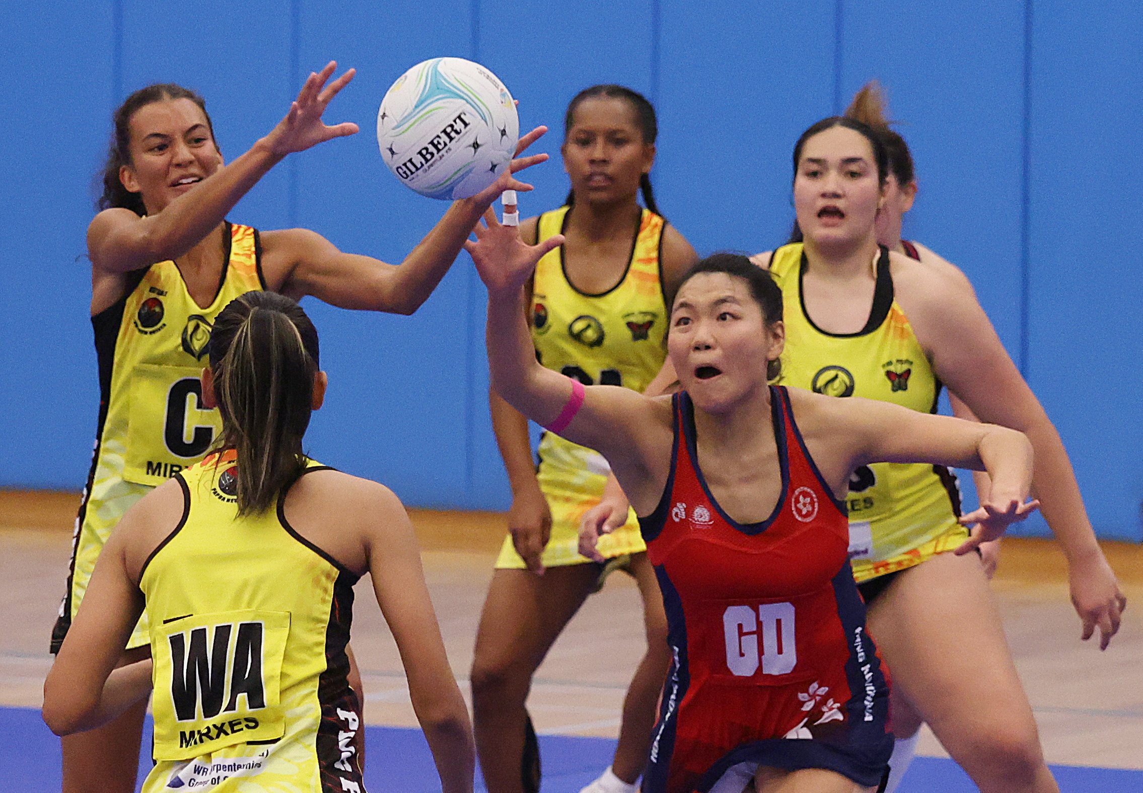Hong Kong’s Lo Fung-yee is surrounded by Papua New Guinea players during the final at Kowloon Park Sports Centre. Photo: Yik Yeung-man