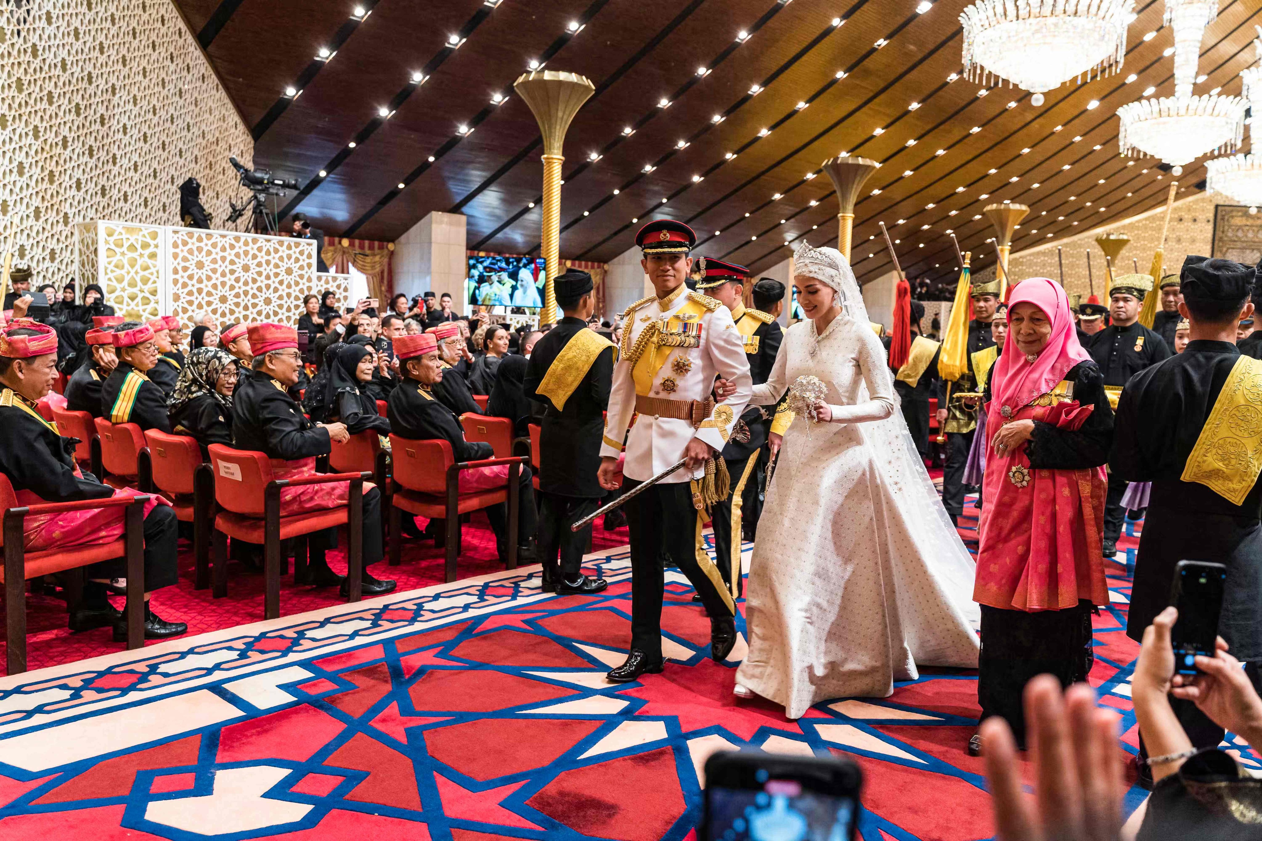 Prince Abdul Mateen and Anisha Rosnah walk down the aisle during their wedding reception at Istana Nurul Iman in Bandar Seri Begawan on Sunday. Photo: AFP