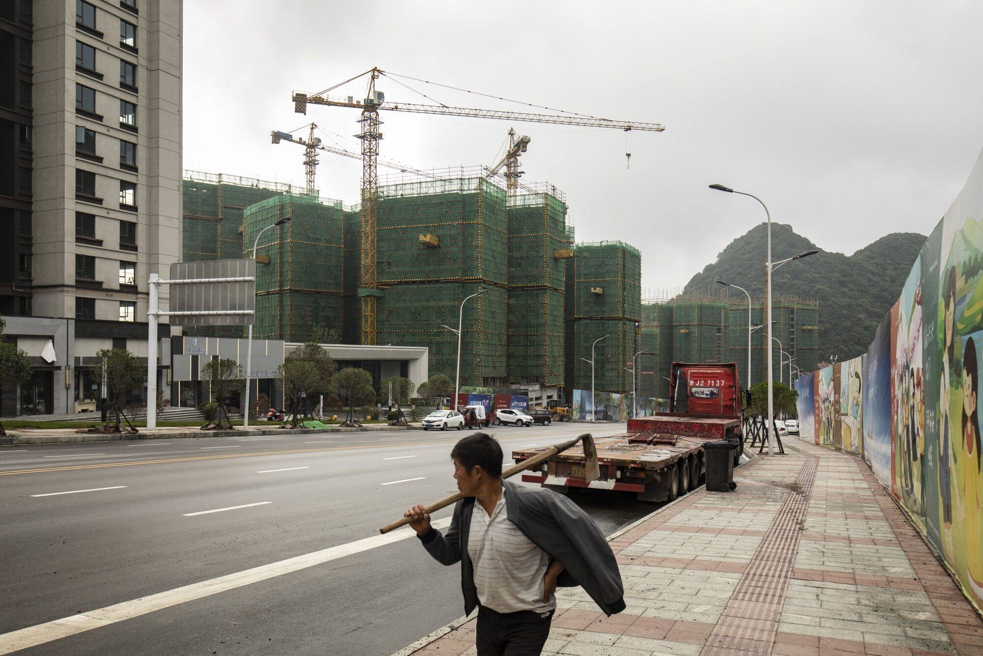 A pedestrian walks by a housing project in Liupanshui, Guizhou province, China,  June 16, 2023. Photo: Bloomberg