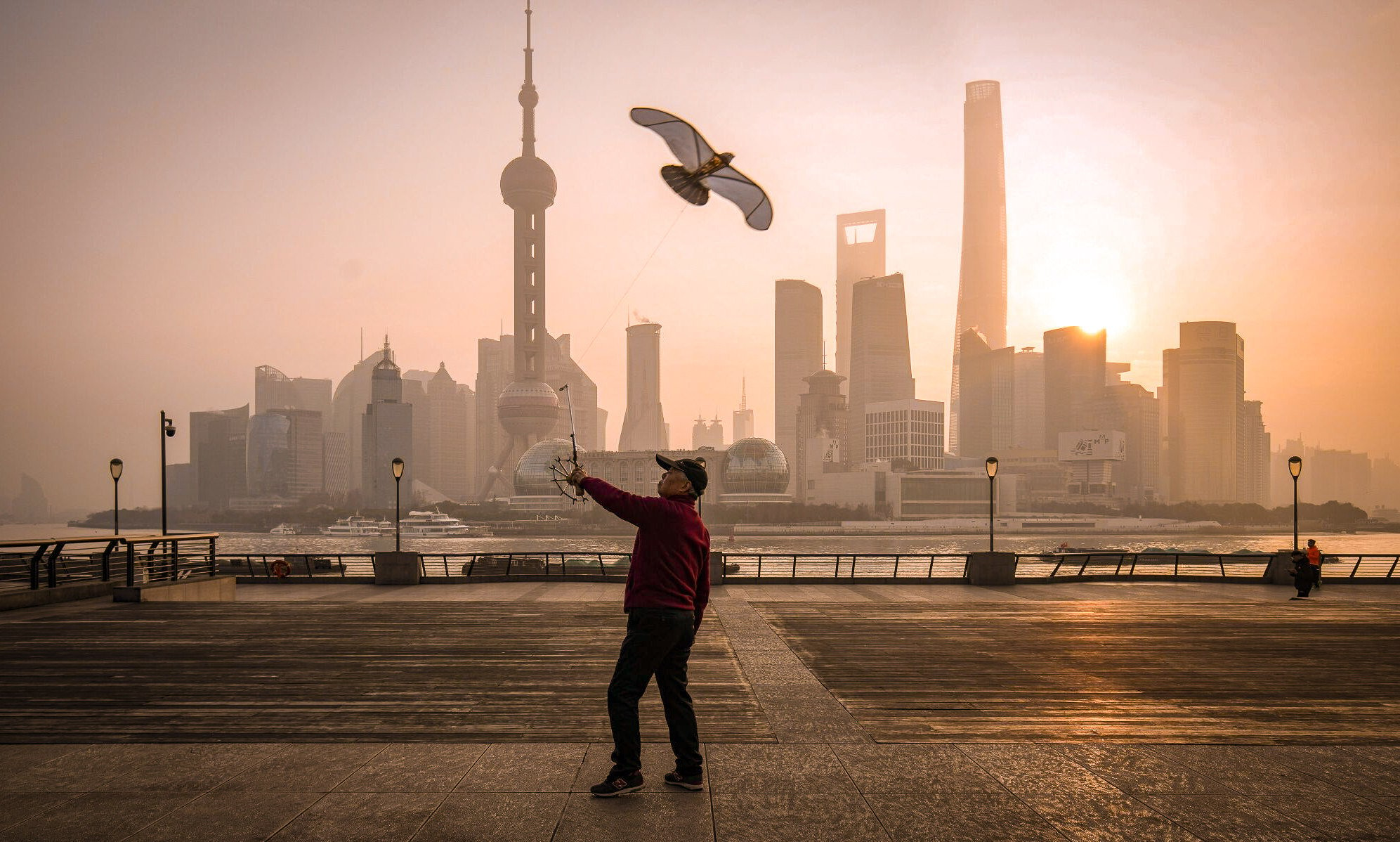 A person flies a kite on the Bund in front of buildings in Pudong’s Lujiazui Financial District in Shanghai on January 9, 2024. Photo: Bloomberg