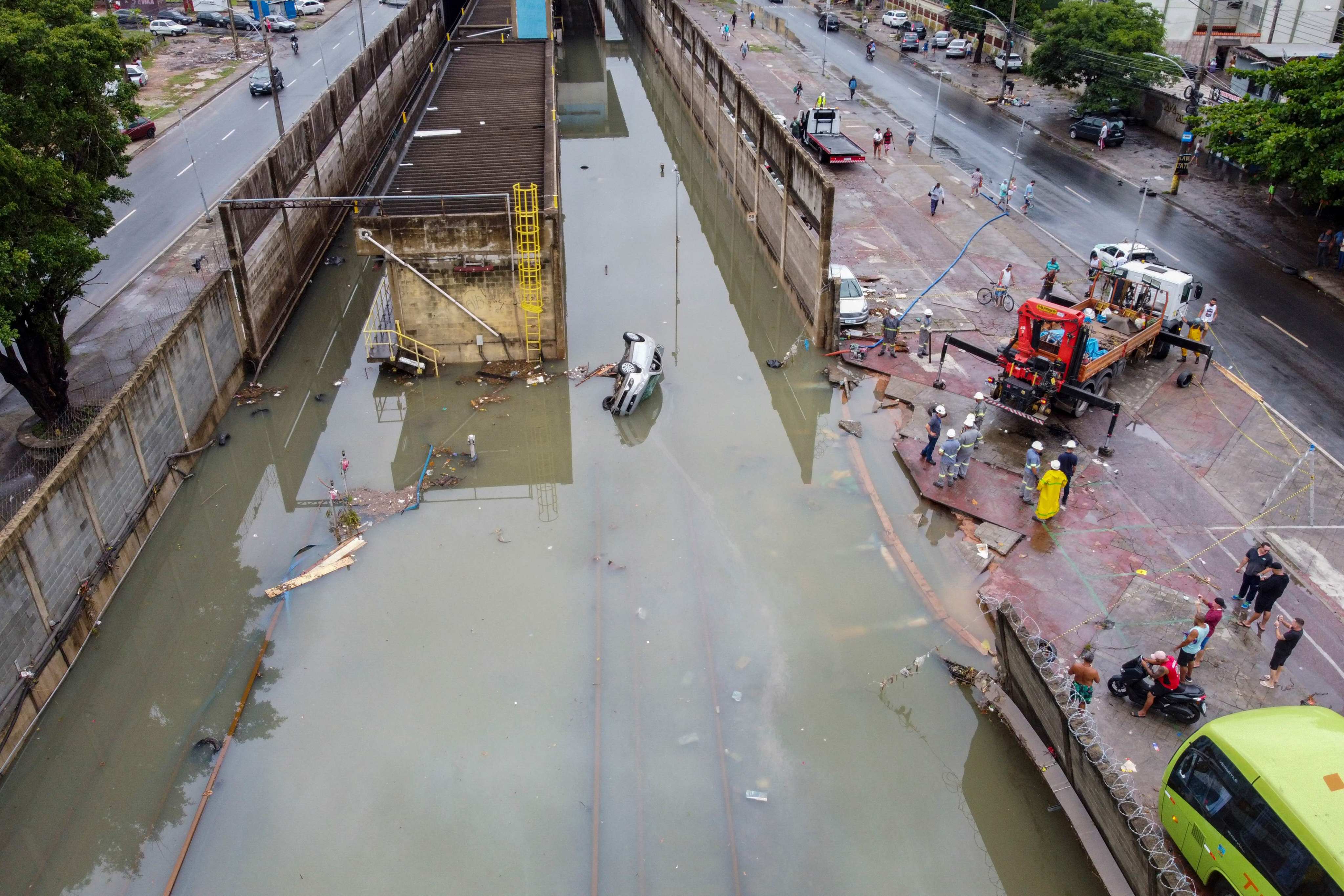 People look at a car that was swept into the flooded railways of the Acari metro station after heavy rains caused destruction in the suburbs of Rio de Janeiro, Brazil on Sunday. Photo: AFP