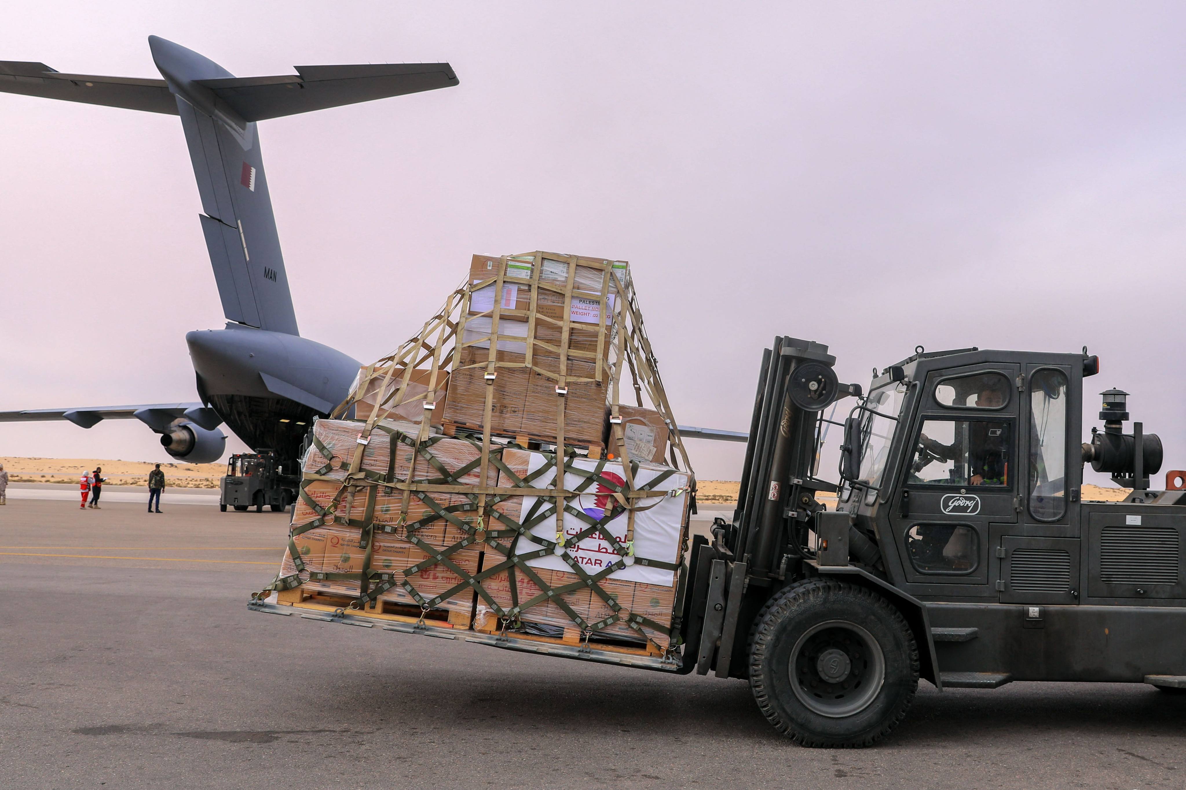 A fork-lift transports boxes as two military planes from Qatar containing aid for Gaza, including medicine for hostages, are unloaded at El-Arish airport in Egypt on Wednesday. Photo: AFP
