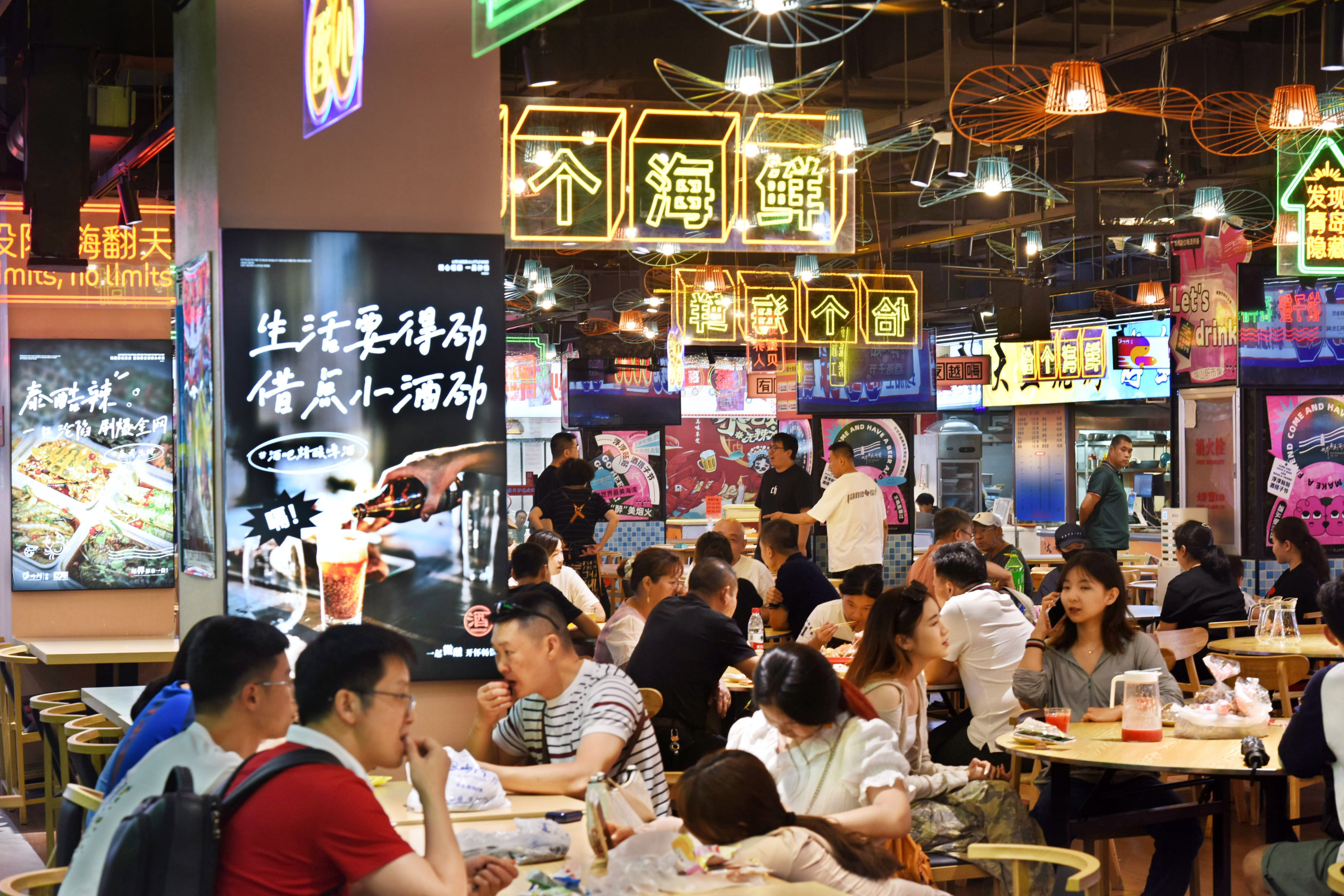 Diners gather at Fushansuo Market in Shinan, Qingdao, in Shandong province, on August 7. China’s overt focus on manufacturing implies keeping the yuan weak, but this reduces the purchasing power of households, shifting wealth from consumers to manufacturing. Photo: Xinhua