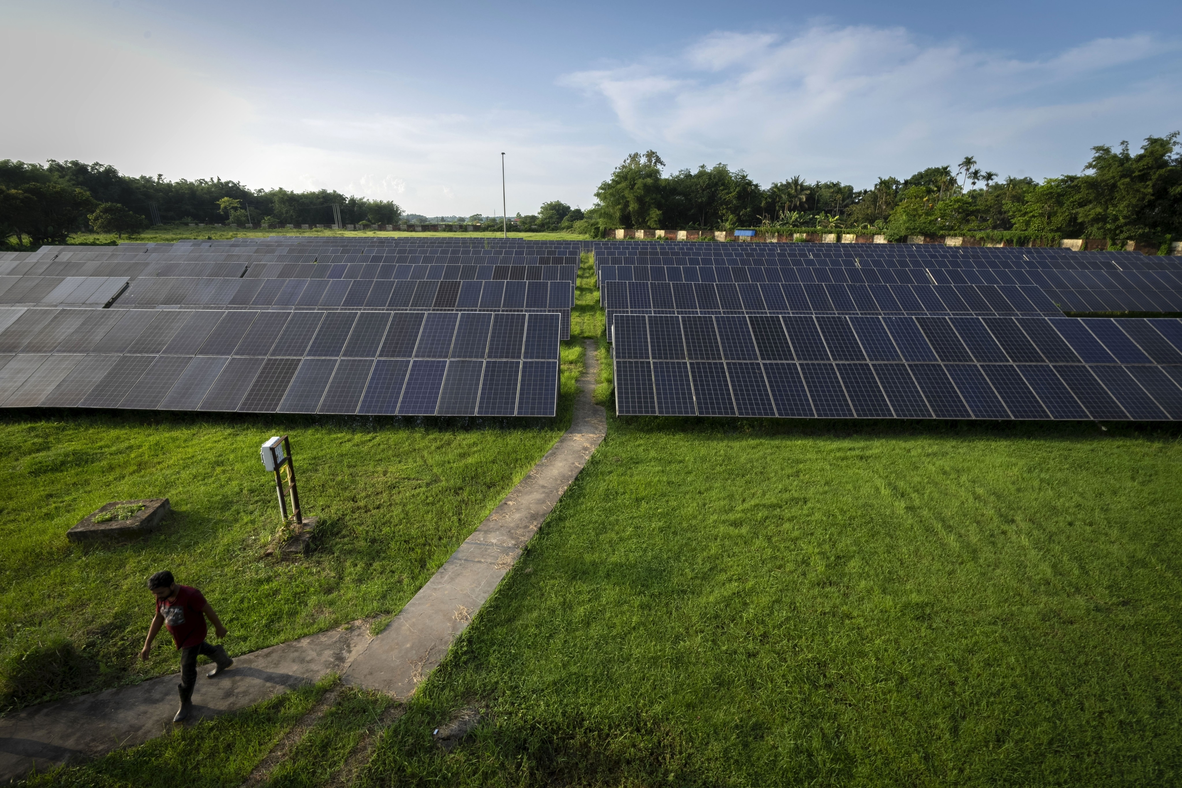 An employee walks away from solar panels near a hydrogen plant at Oil India Limited in Jorhat, India, on August 17, 2023. Photo: AP