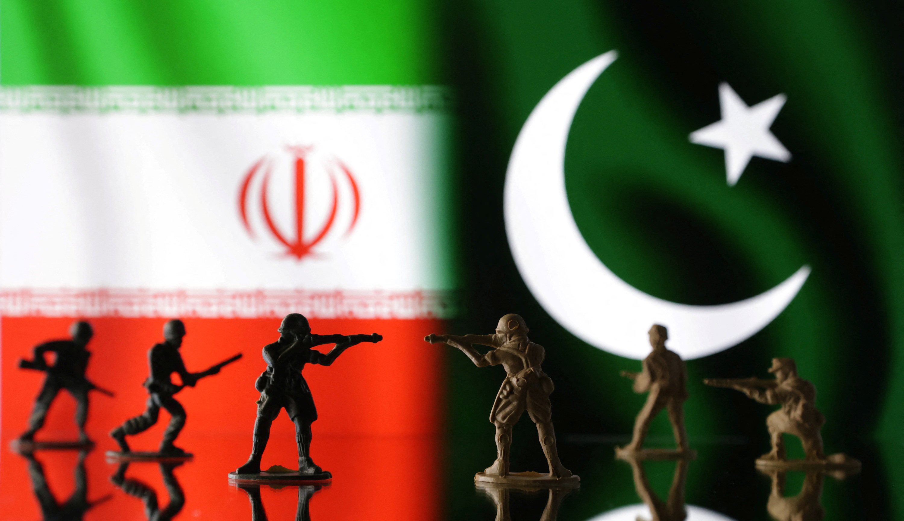 Miniature soldiers in front of Iranian and Pakistani flags. Photo: Reuters
