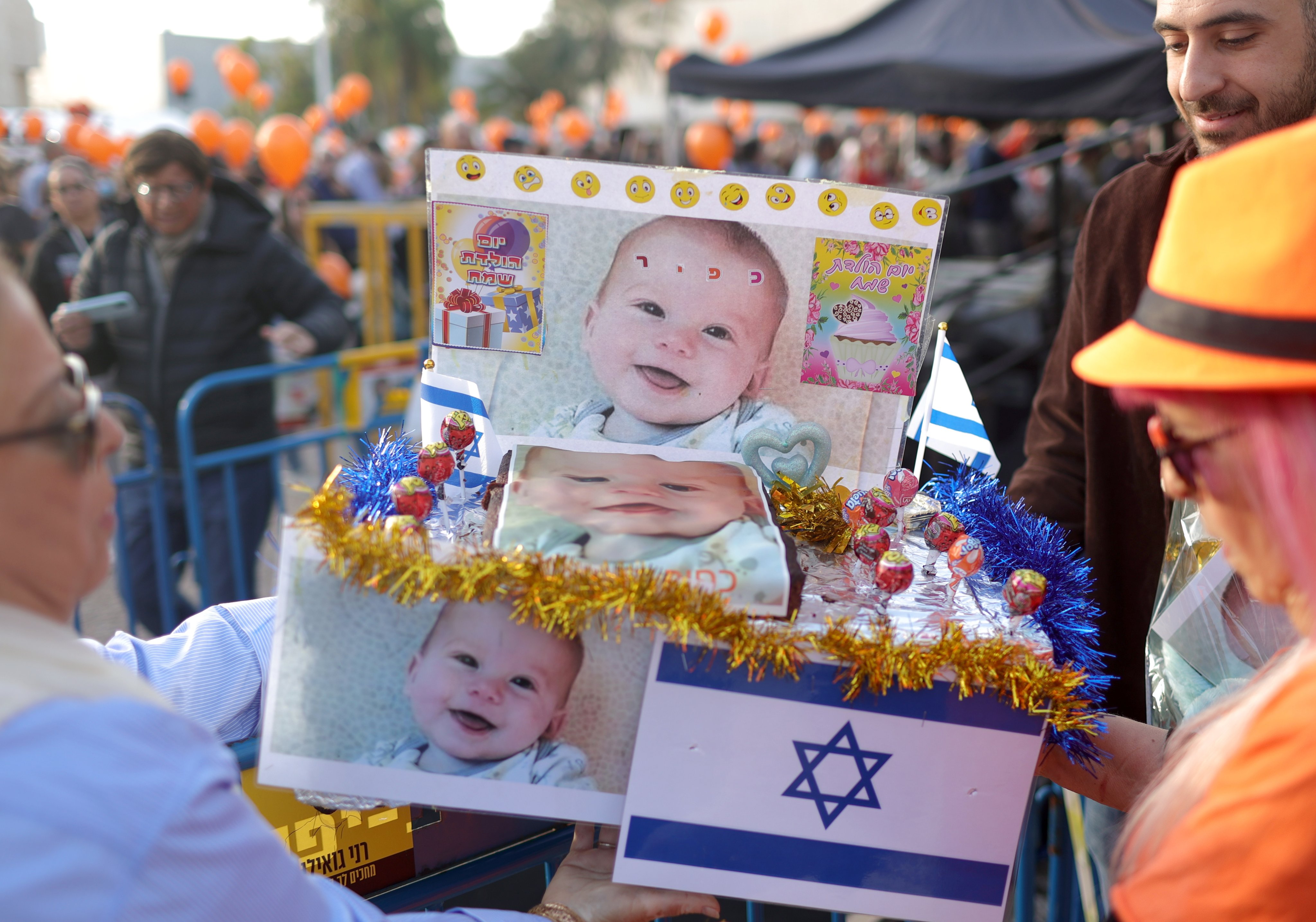 People hold a birthday cake to mark the first birthday of Israeli toddler Kfir Bibas, who is held hostage by Hamas in Gaza, outside the Kirya military base in Tel Aviv, Israel on Thursday. Photo: EPA-EFE