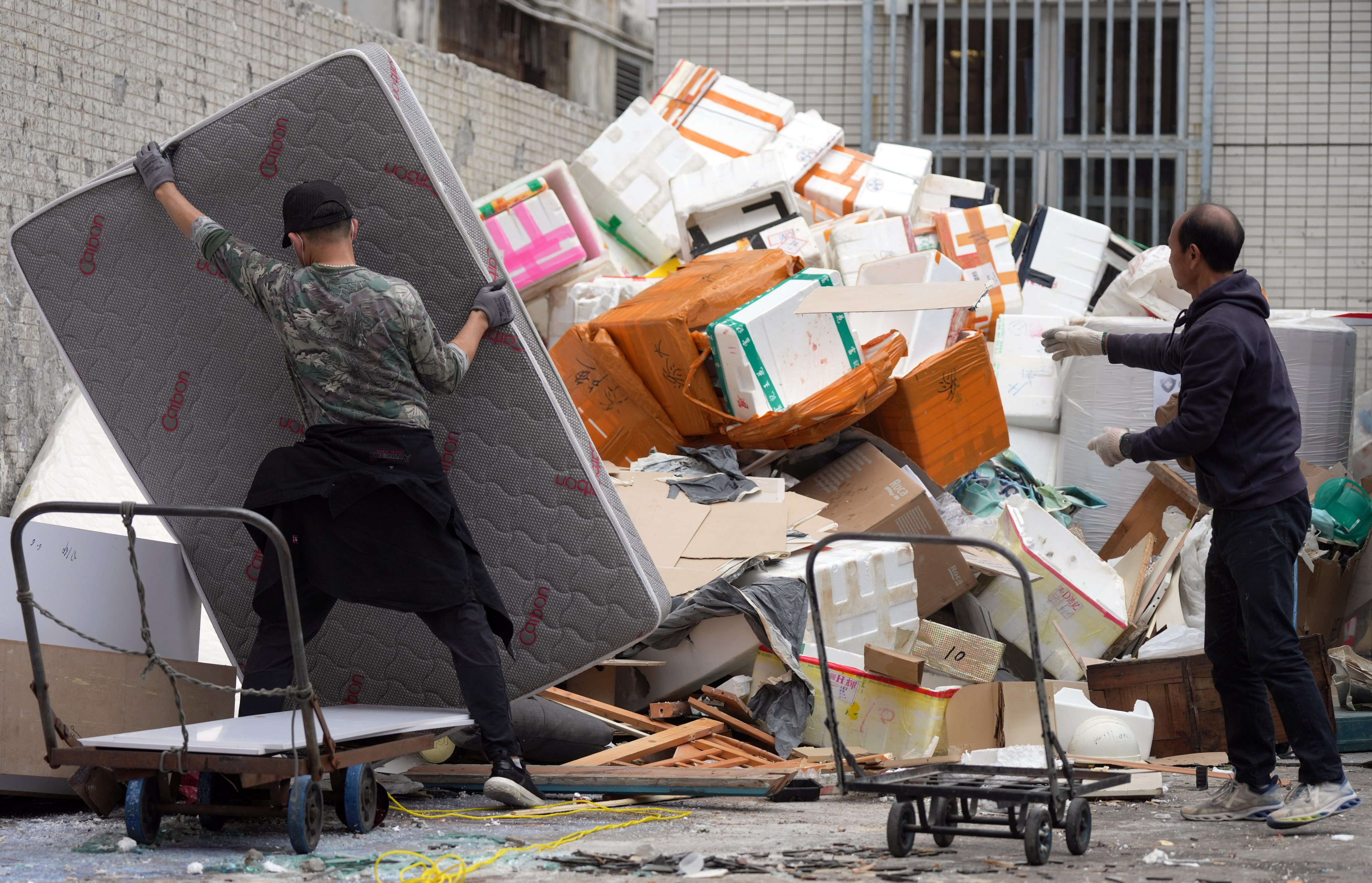 Workers handle waste at a collection point. The scheme was earlier delayed because of concerns over a staff shortage. Photo: Eugene Lee