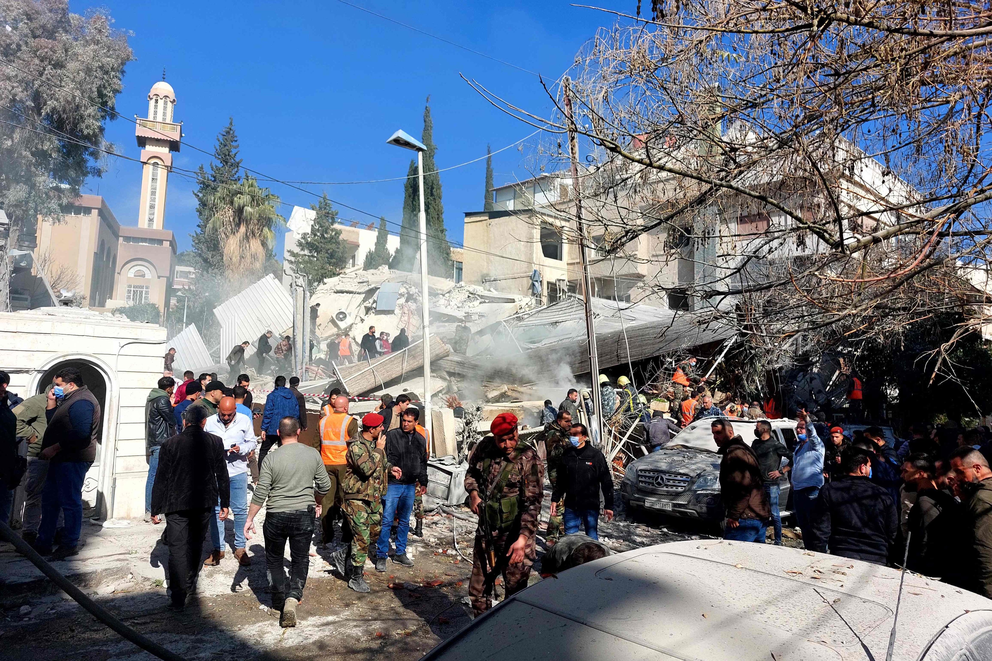 People and security forces gather in front of a building destroyed in a reported Israeli strike in Damascus in Syria on Saturday, as regional tensions soar over the Israel-Gaza war. Photo: AFP