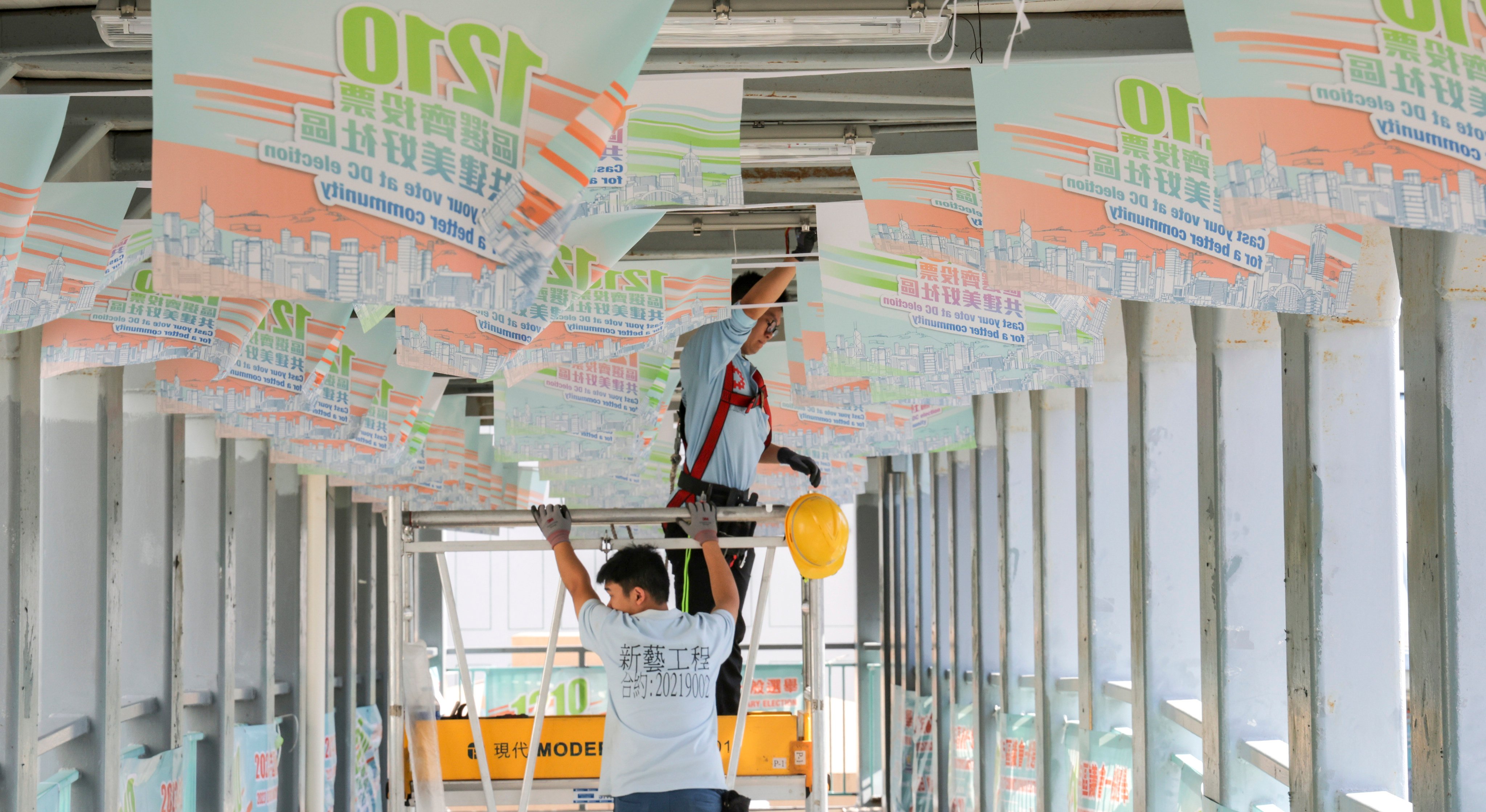 Workers in November hang up banners to promote the December 10 district council election. Photo: Jelly Tse