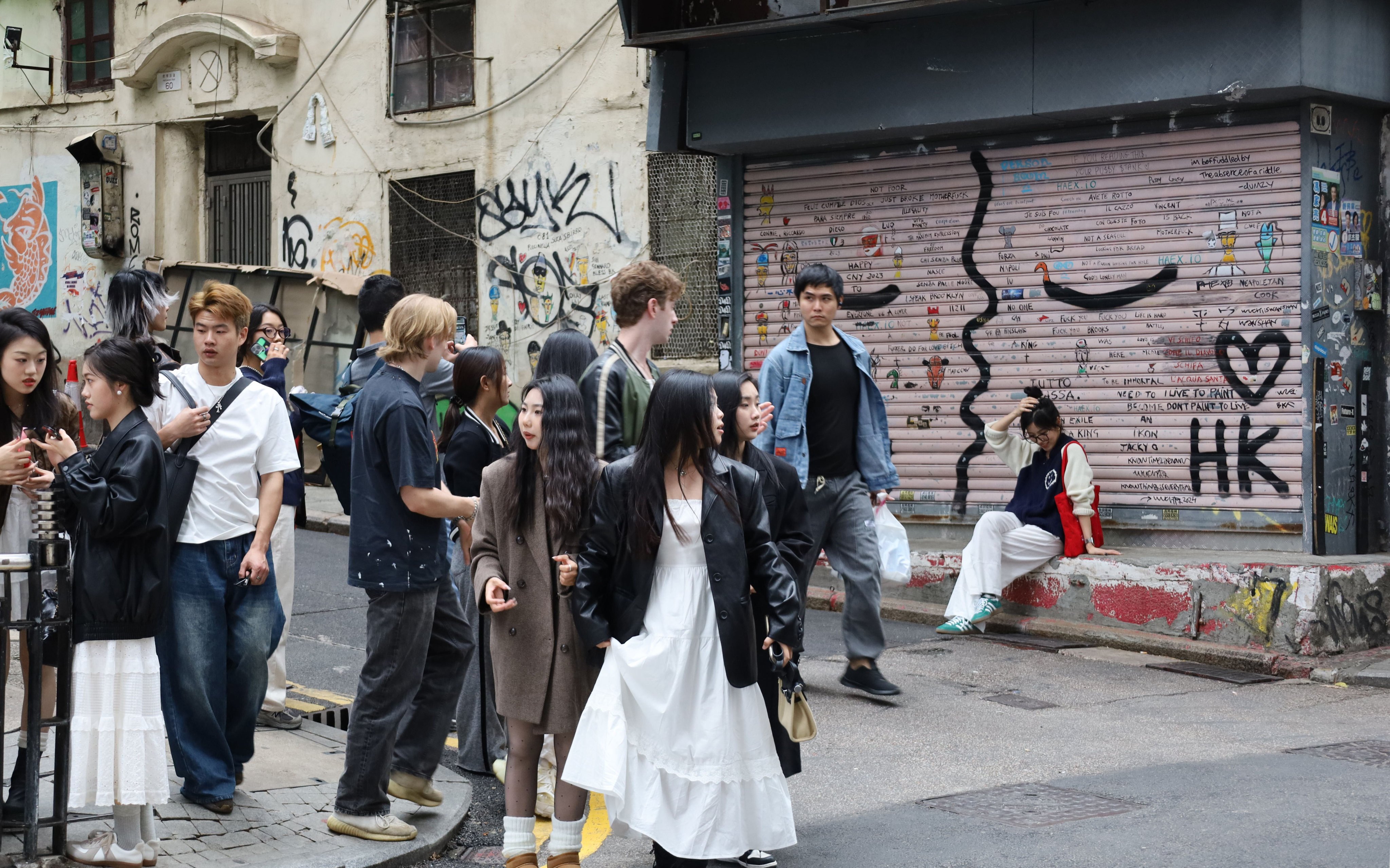 Tourists post for photos in front of graffiti on Central’s Peel Street. Photo: Wynna Wong