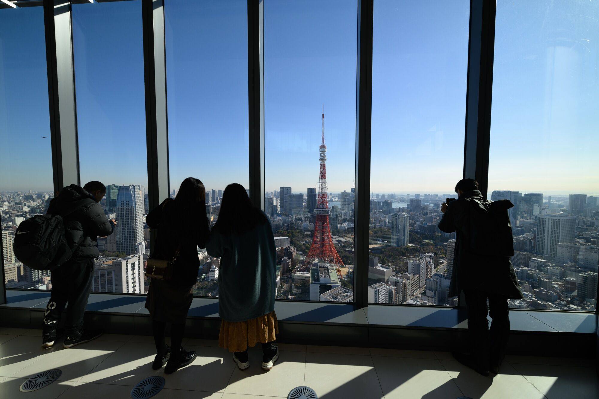 Visitors look out the Tokyo Tower from the observatory at the Azabudai Hills Mori JP Towe in Tokyo, Japan, on Tuesday, Dec. 26,. Vietnam sends the largest number of technical trainees to Japan under the programme, according to the Organization for Technical Intern Training. Photo: Bloomberg