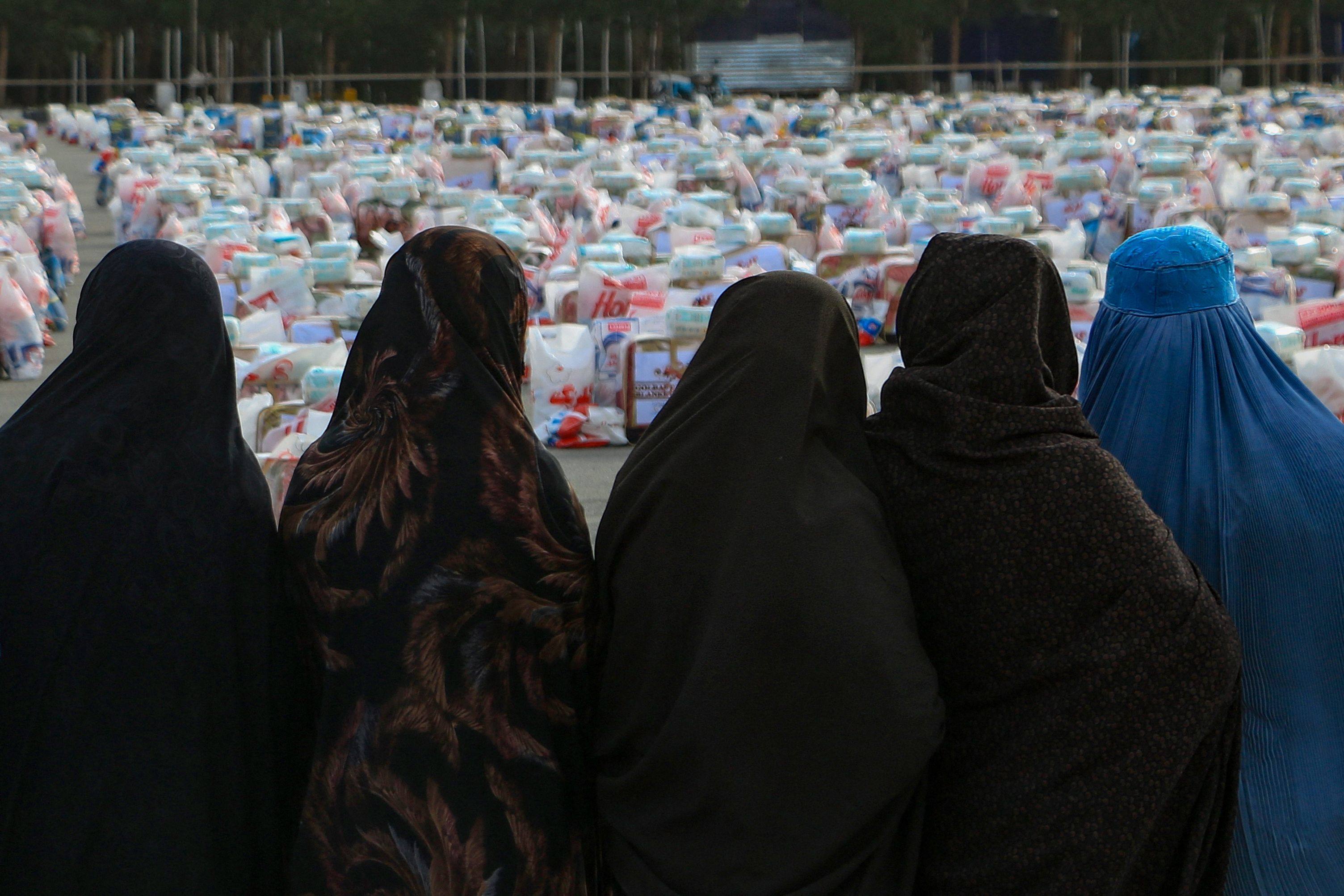 Afghan women wait to receive aid packages which includes food, clothes, and sanitary materials, distributed by a local charity foundation in Herat. The Taliban have barred women from most areas of public life. Photo: AFP