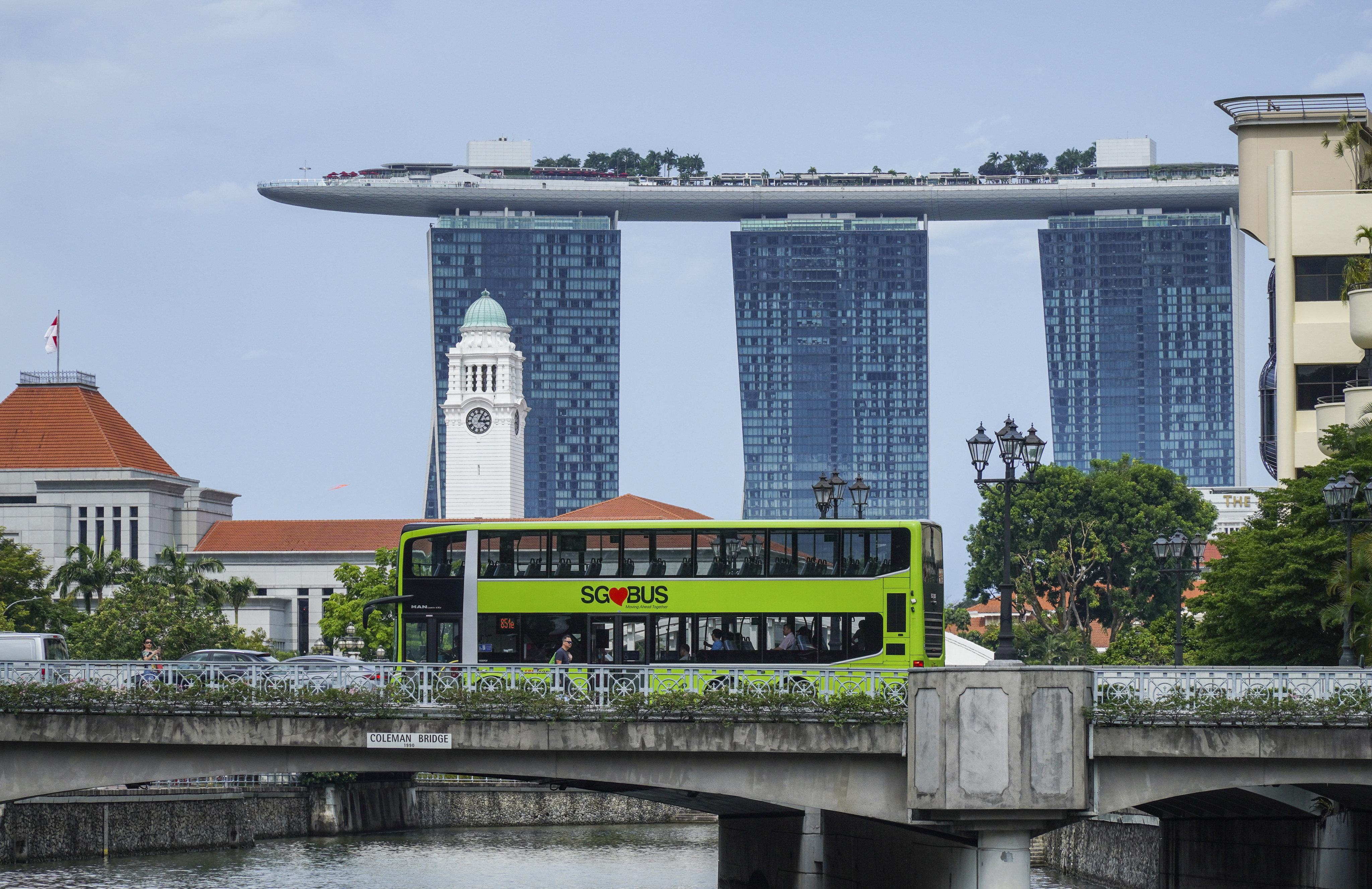 A public bus passes a bridge in Clarke Quay in front of the Marina Bay Sands Hotel in Singapore. SimplyGo was introduced in 2019 by LTA to offer a range of digital ticketing and e-payment options for transit. The system allows cardholders to view fare history and top-up card balance on-the-go via a mobile application. Photo: Roy Issa