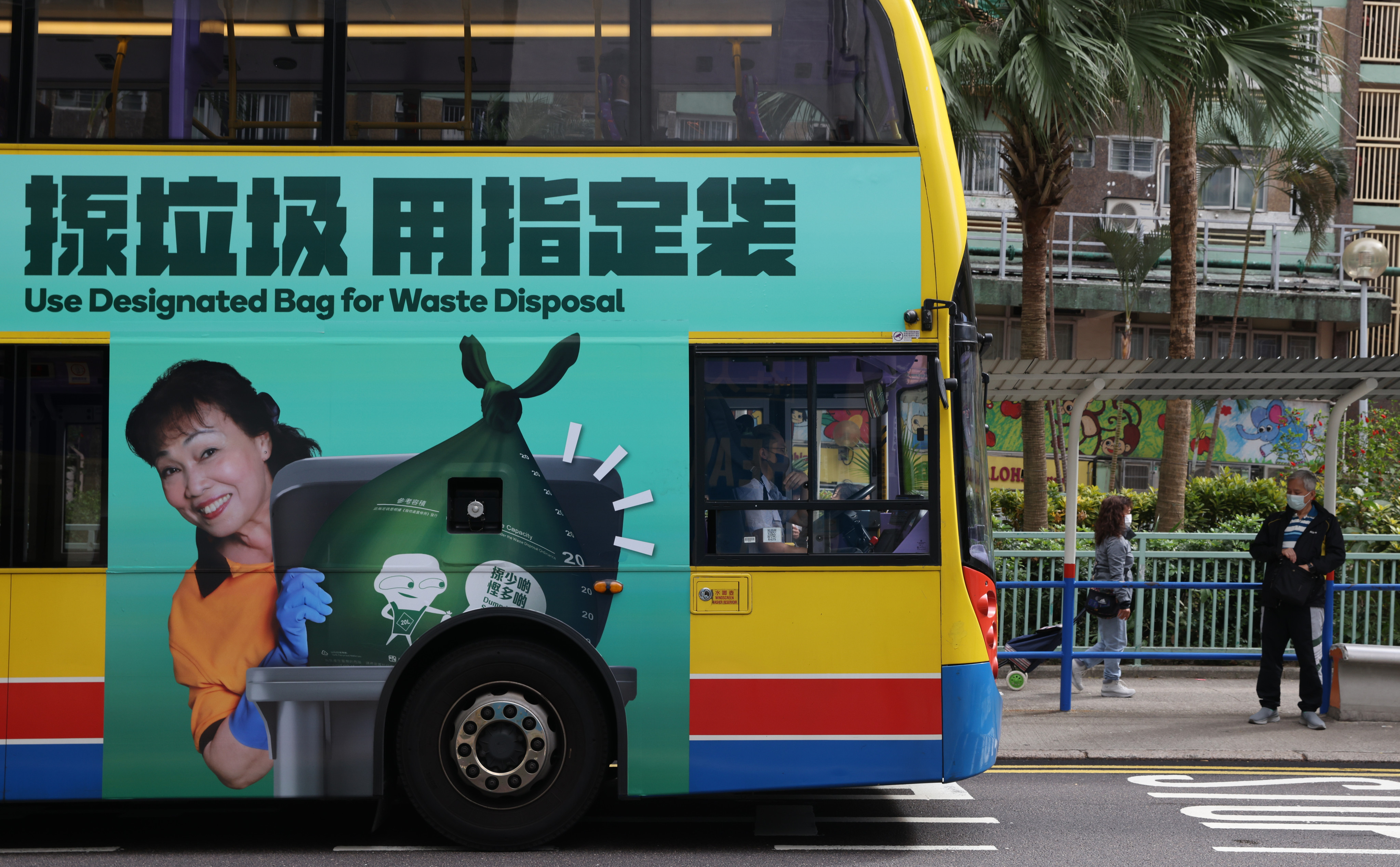 A government advertisement for the waste charging scheme is displayed on a bus in Chai Wan on January 19. Delaying the scheme might merely extend the period before the public can learn and therefore adapt to the scheme. Photo: Yik Yeung-man