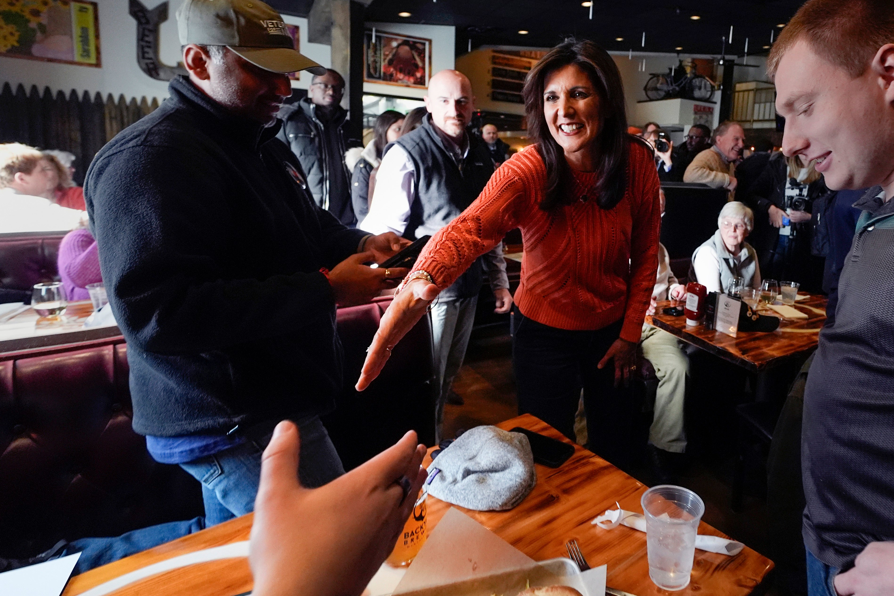 Nikki Haley shakes hands with a patron during a campaign stop at a brewery in Manchester, New Hampshire. Photo: AP