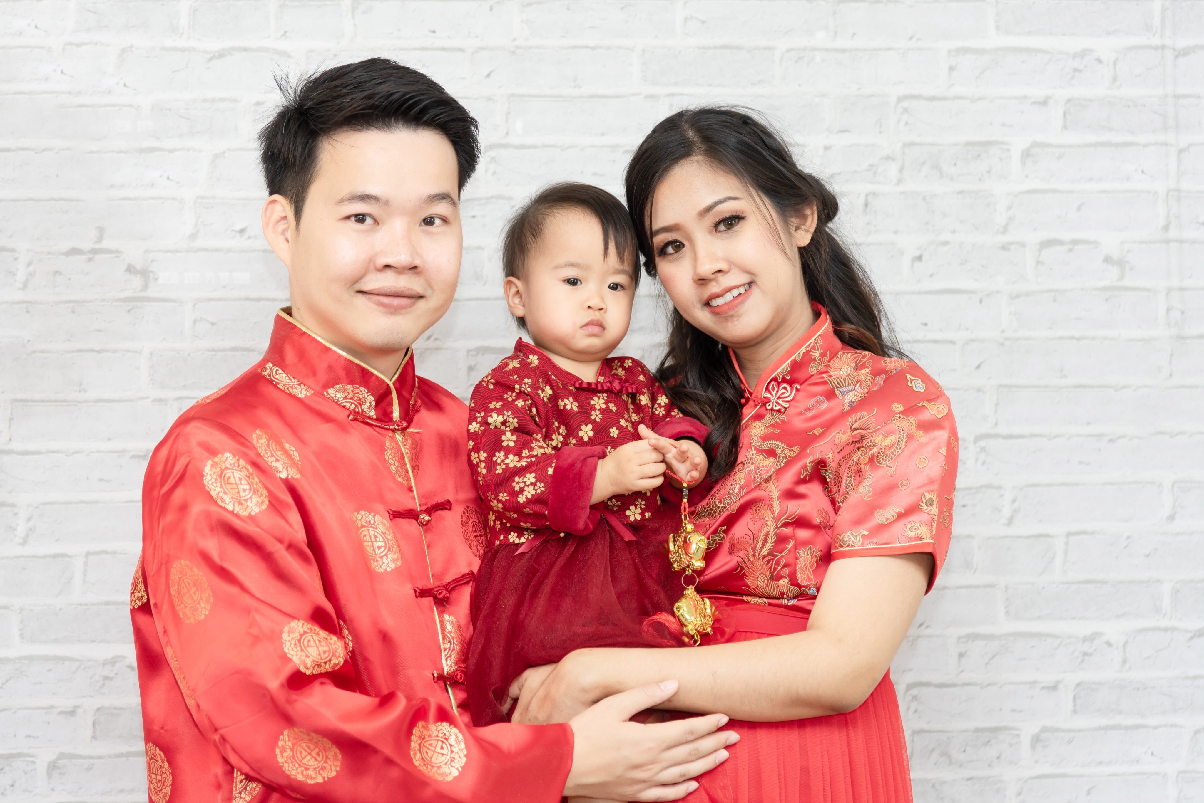 To ensure good luck in the year to come, wear red clothing that’s new at Chinese New Year, like this family. Photo: Shutterstock Images