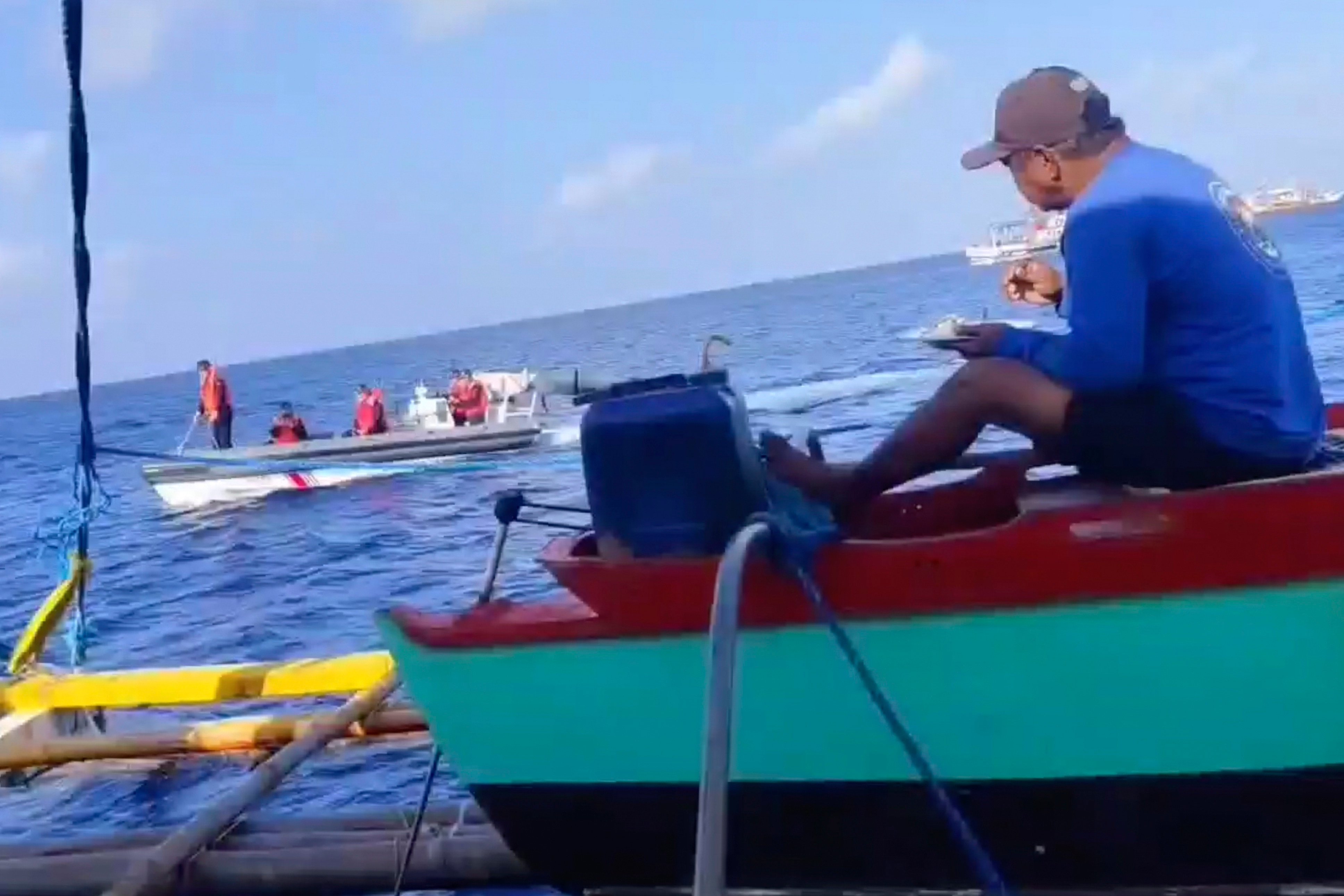 A Chinese coastguard ship passes by a Philippine fishing boat at the disputed Scarborough Shoal. Photo: Joely Saligan/AP